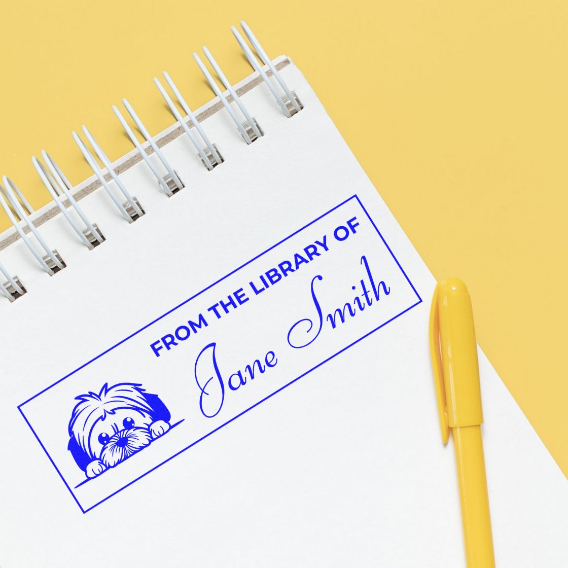 Custom library rubber stamp on notebook reading From the Library of Jane Smith for personalized book ownership.