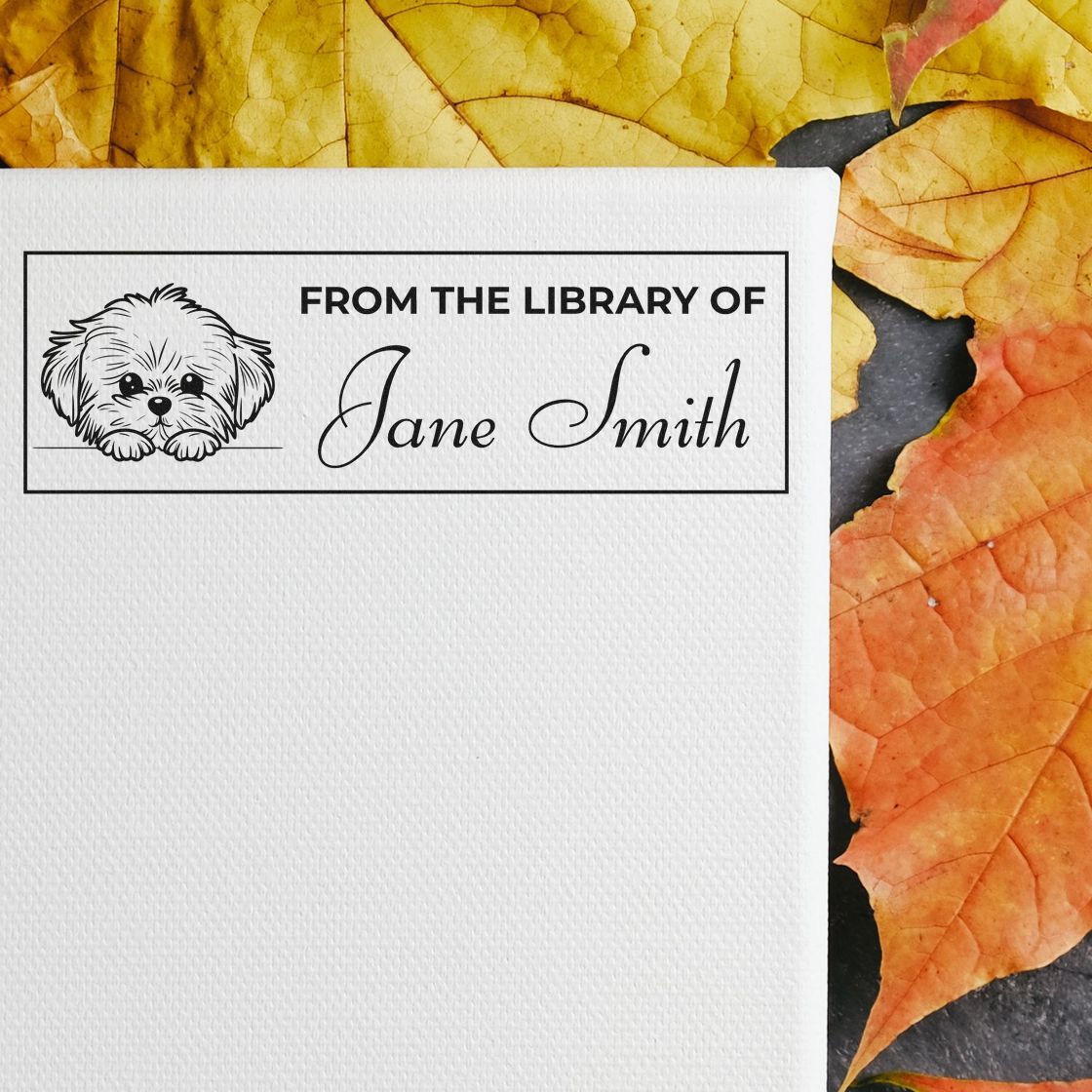 Custom rubber stamp with dog illustration and From the Library of Jane Smith text for personalized library bookplate marking.