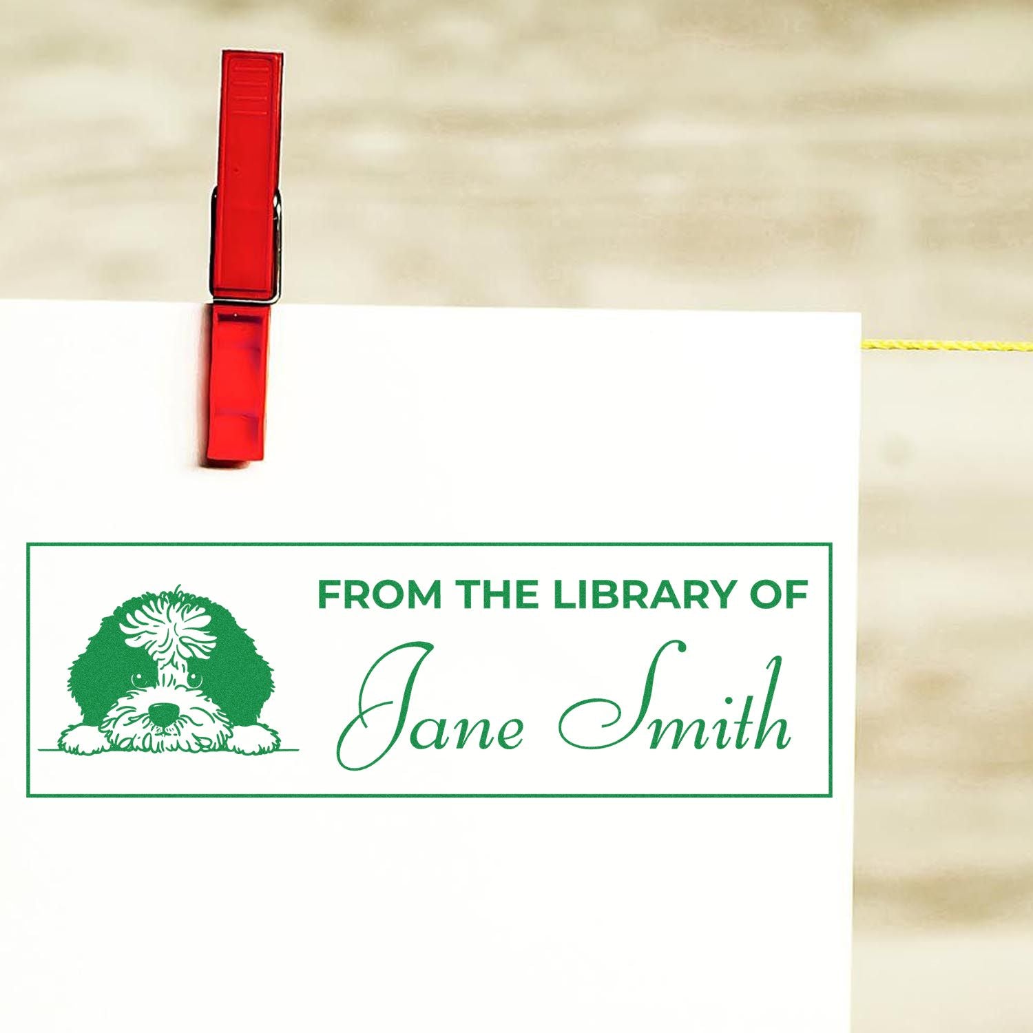 Custom library rubber stamp with dog illustration and From the Library of Jane Smith personalized bookplate on paper.