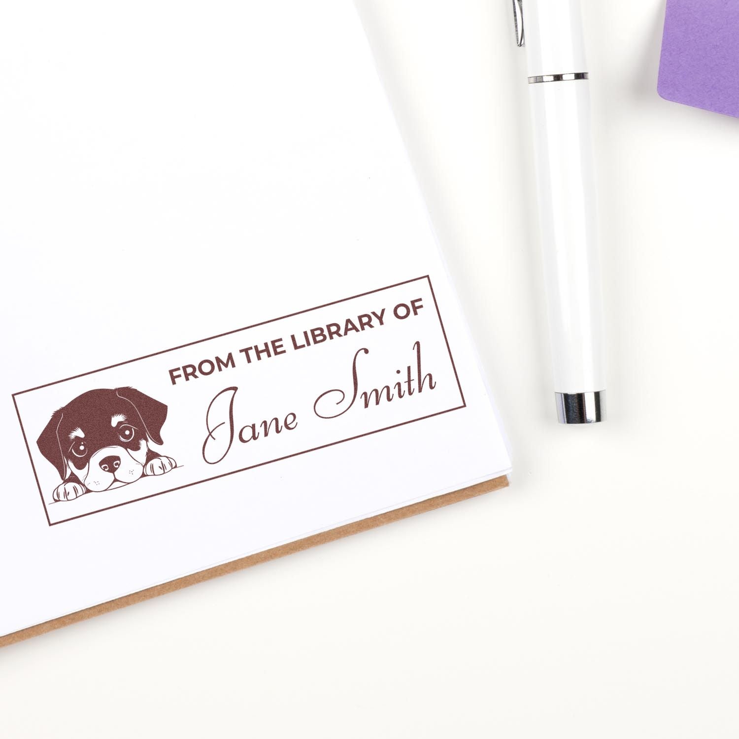 Personalized library rubber stamp with puppy design and From the Library of Jane Smith book owner imprint.
