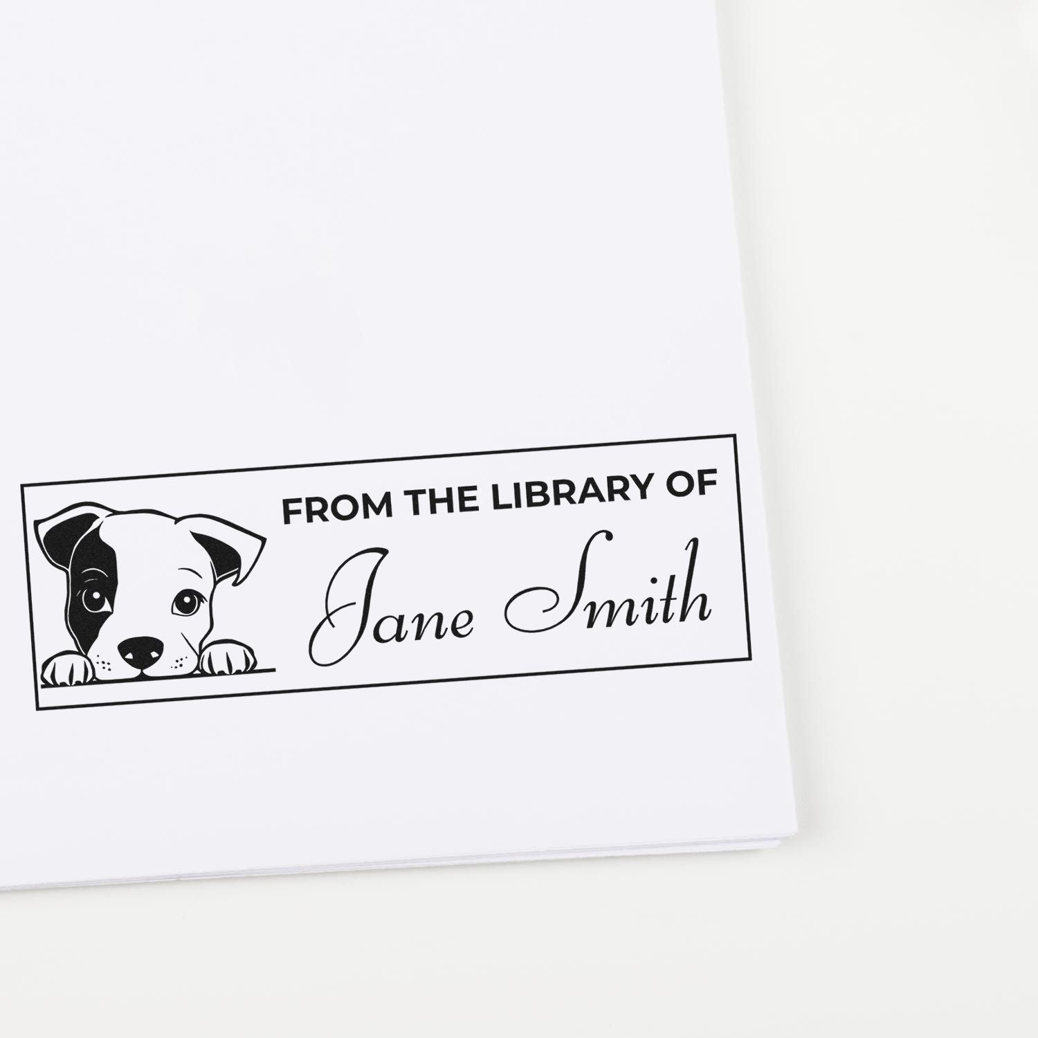 Custom rubber stamp with puppy illustration and From the Library of Jane Smith for personalized book marking.