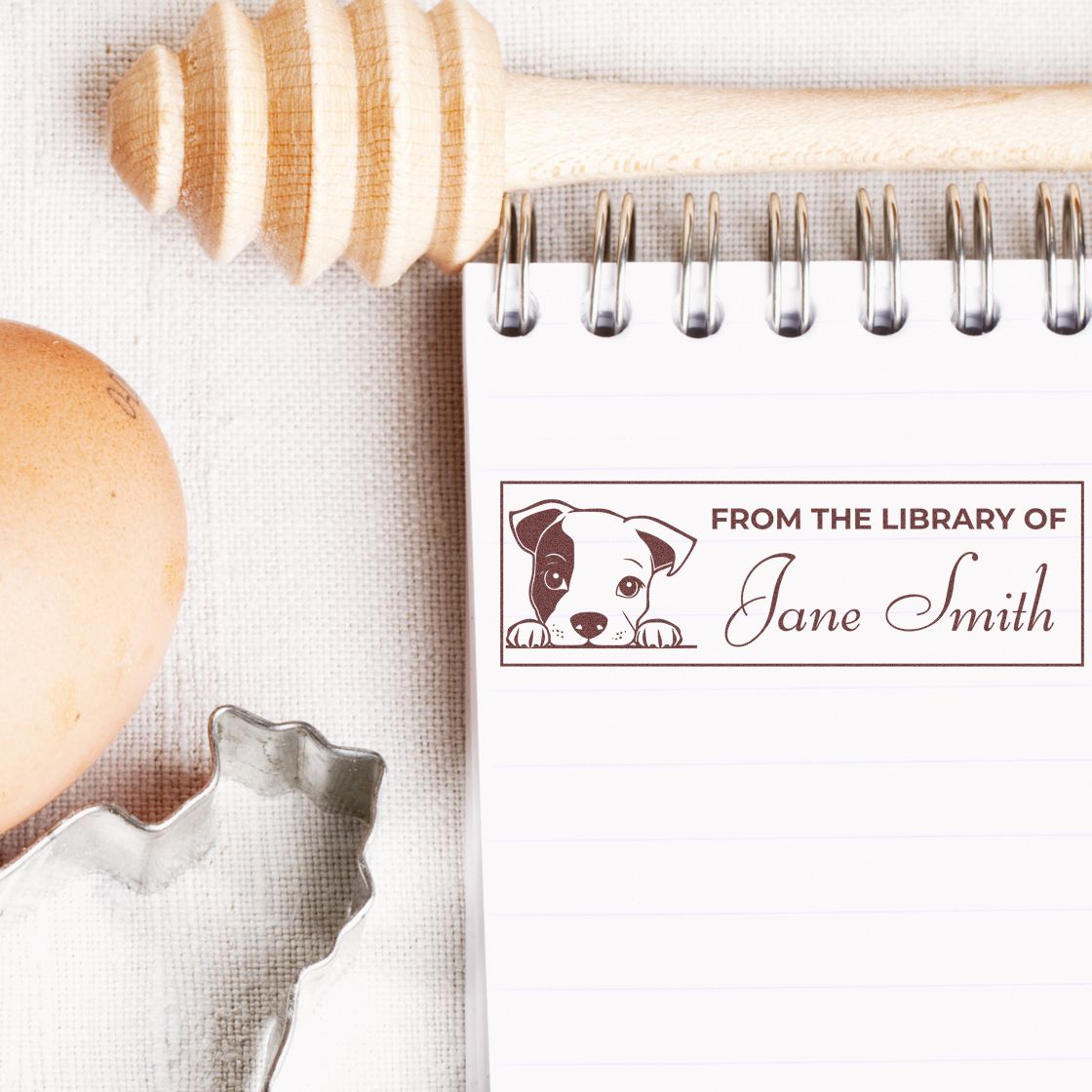 Custom dog library rubber stamp reading From the Library of Jane Smith on a notebook, ideal for personal book stamping.