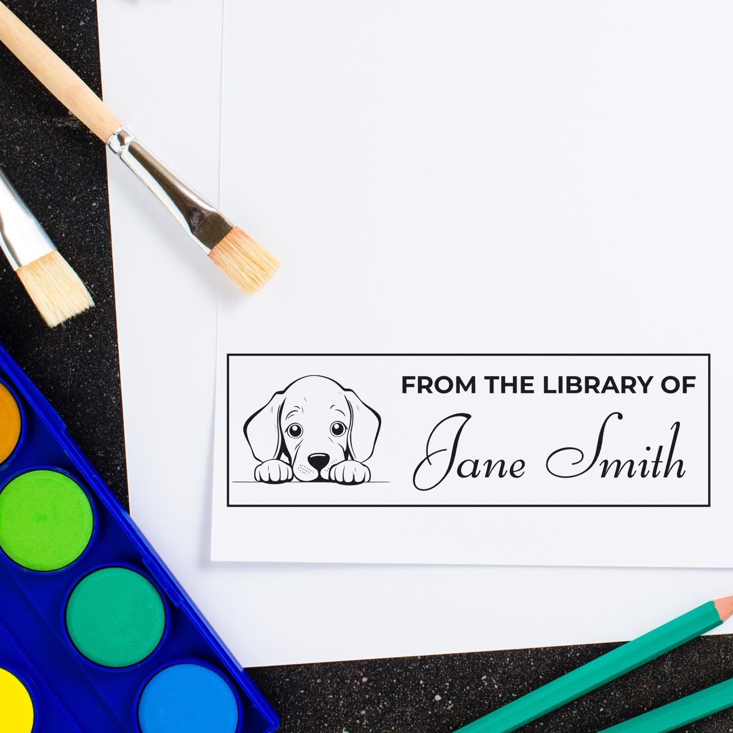 Custom rubber stamp impression with puppy and From the Library of Jane Smith for personalized book labeling.