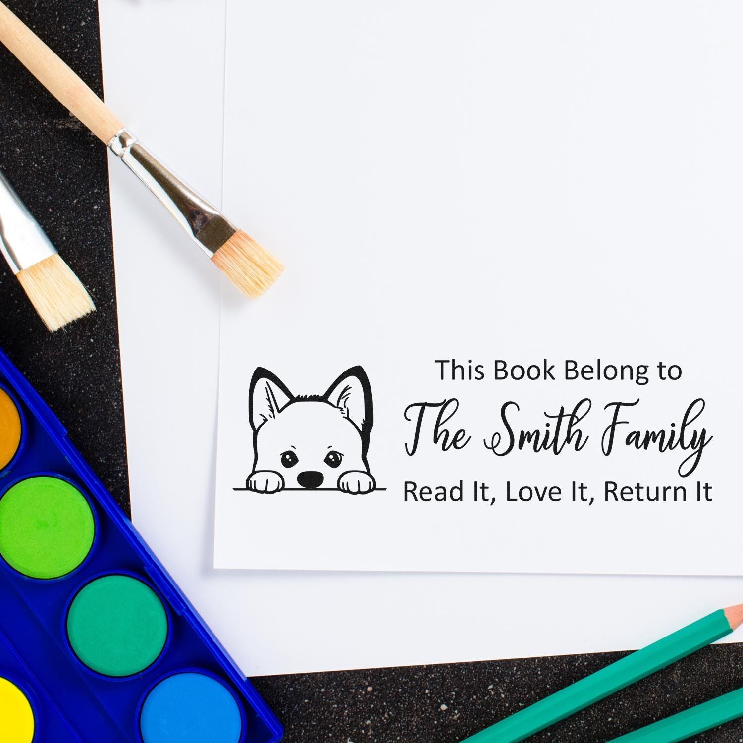 Custom rubber stamp design for books with dog icon and This Book Belongs to The Smith Family return label.