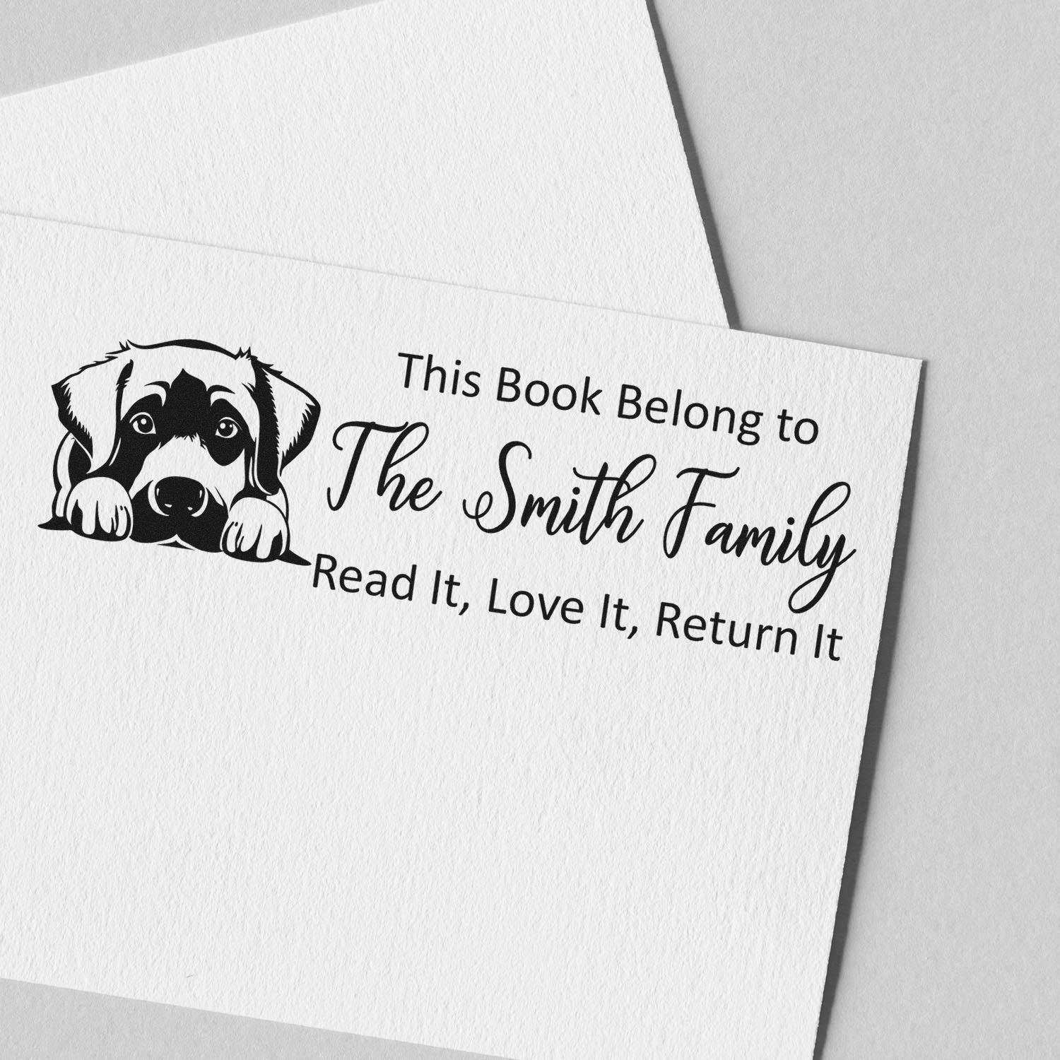 Custom rubber book stamp with dog design for The Smith Family, saying Read It, Love It, Return It.