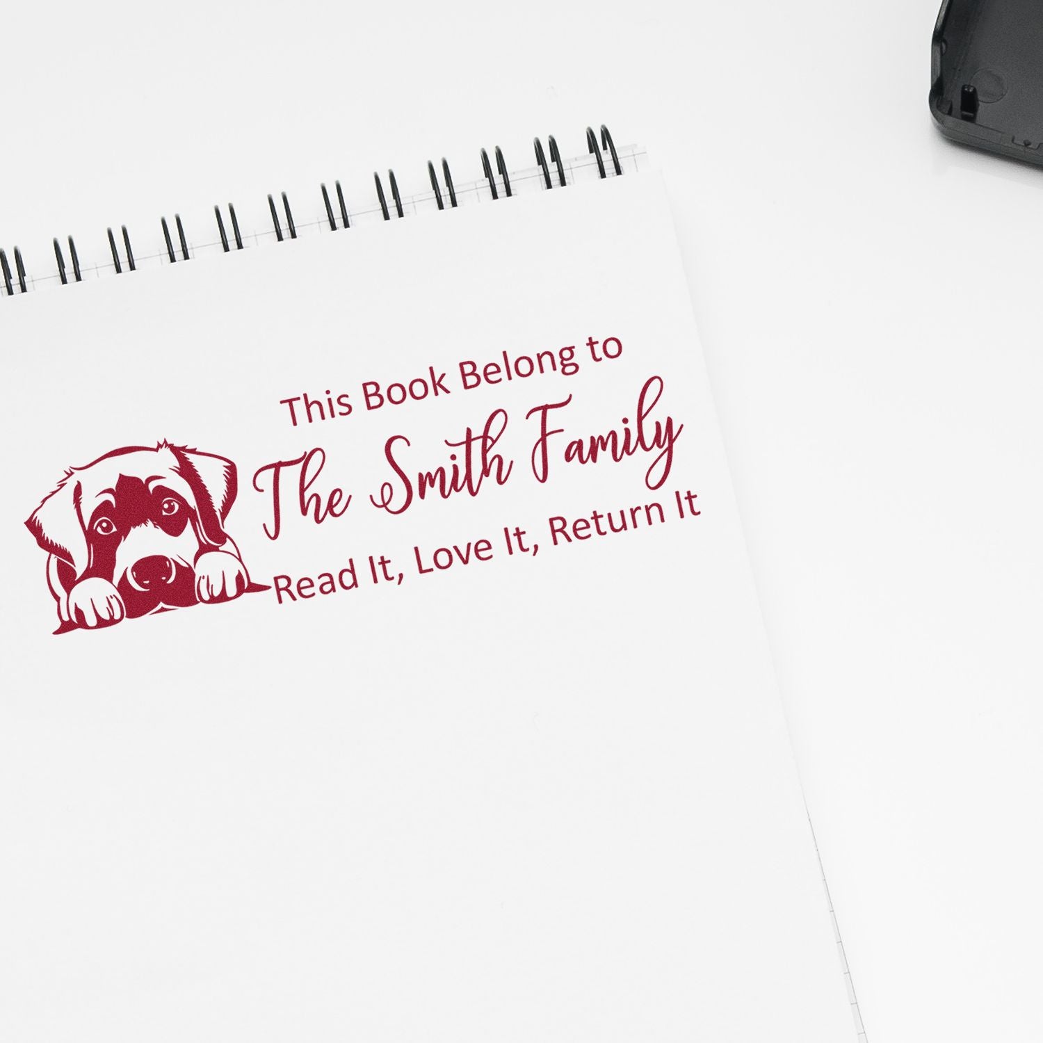 Custom rubber book stamp with dog design and This Book Belongs to The Smith Family text for personalized library books.