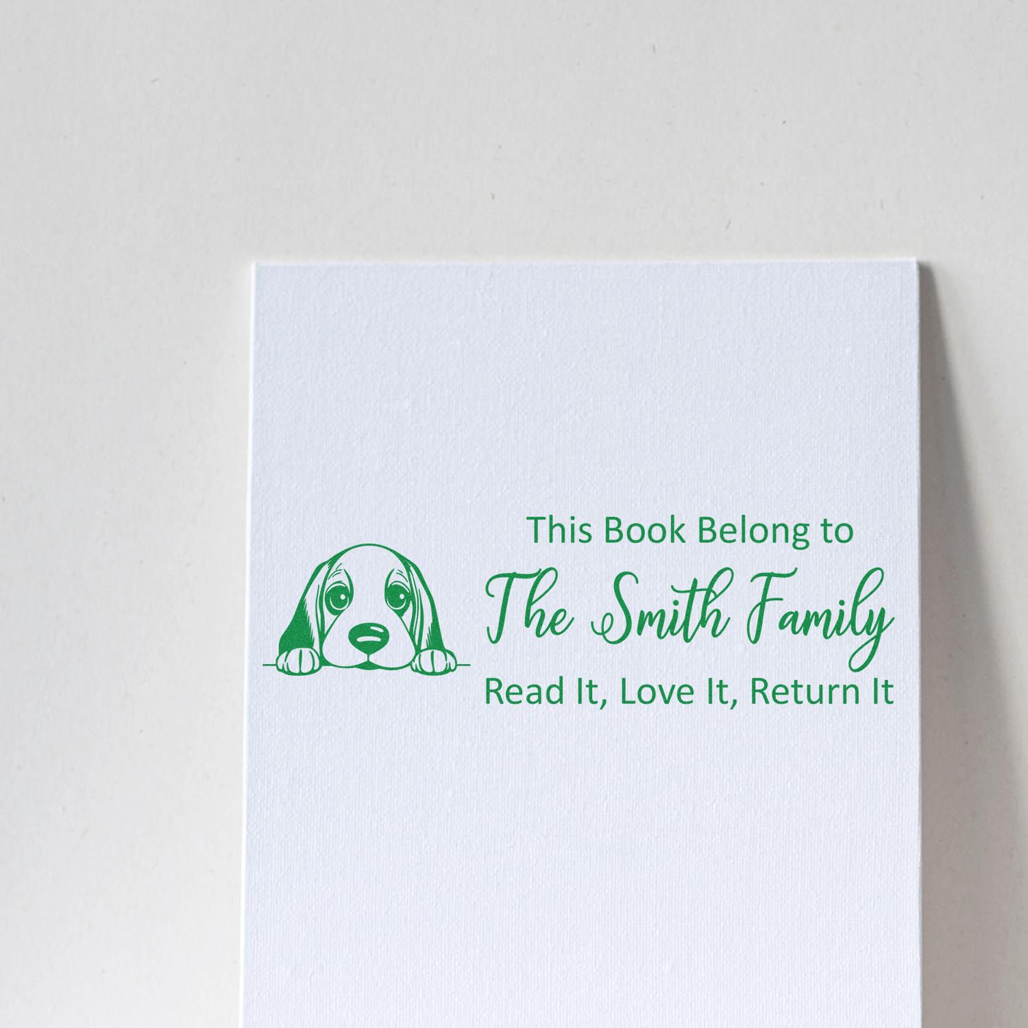 Custom rubber book stamp with dog illustration and This Book Belongs to The Smith Family return-it message.