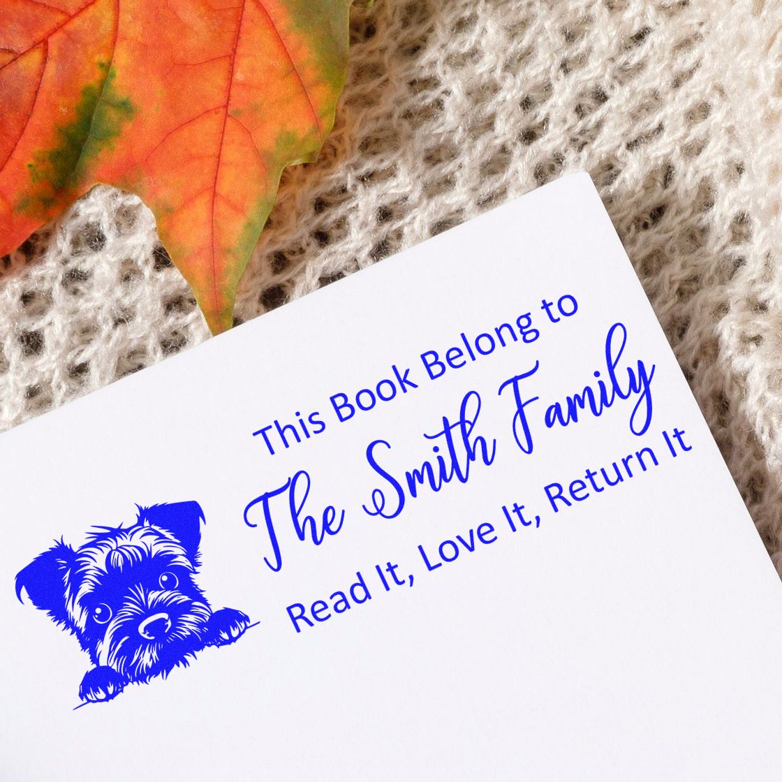 Custom book rubber stamp with dog illustration and family name, saying This book belongs to The Smith Family. Read it, love it, return it.
