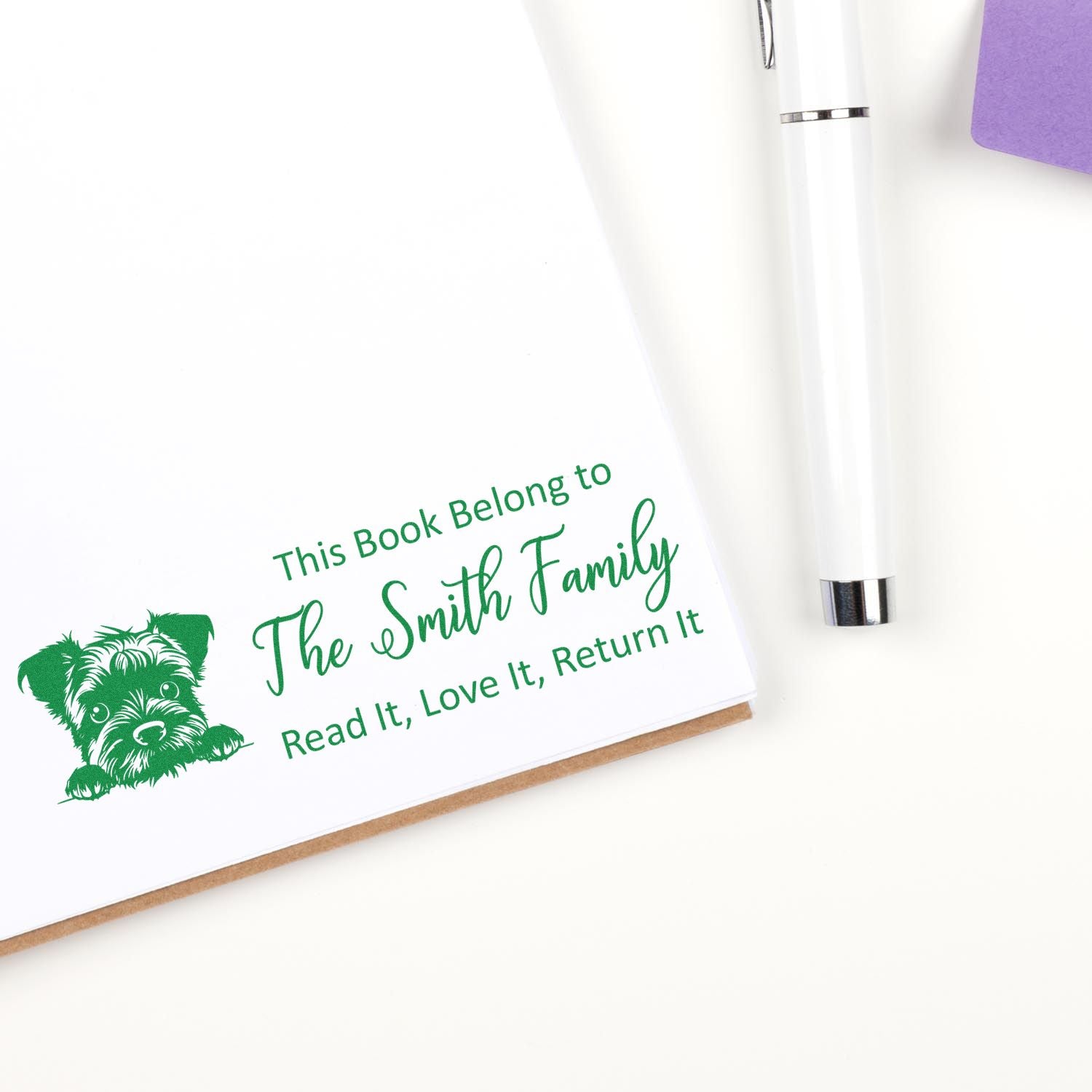 Personalized rubber book stamp with dog icon for The Smith Family, reading This Book Belongs to... to mark library books.