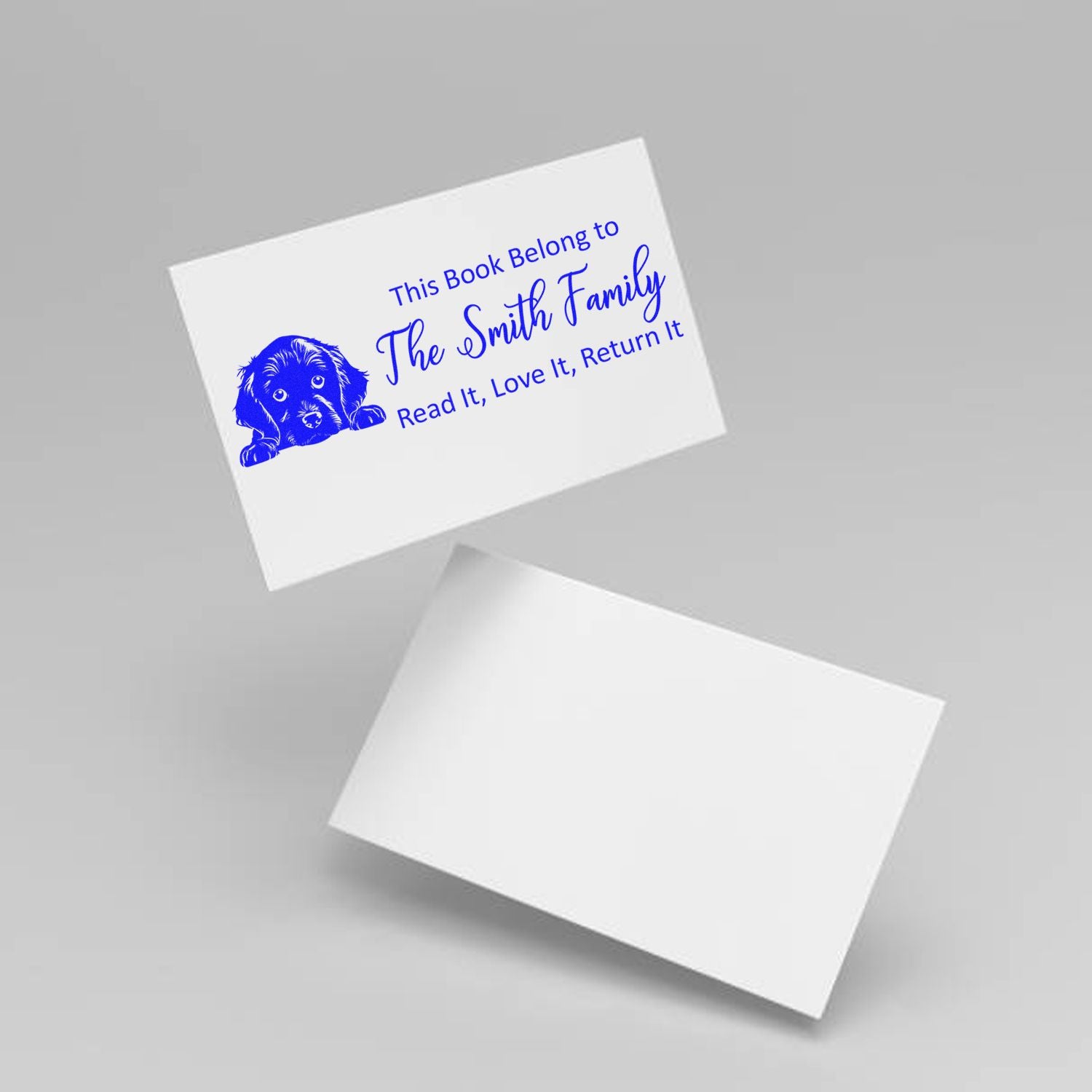 Personalized rubber book stamp with dog art and custom family name, perfect for marking library books and ex libris ownership.