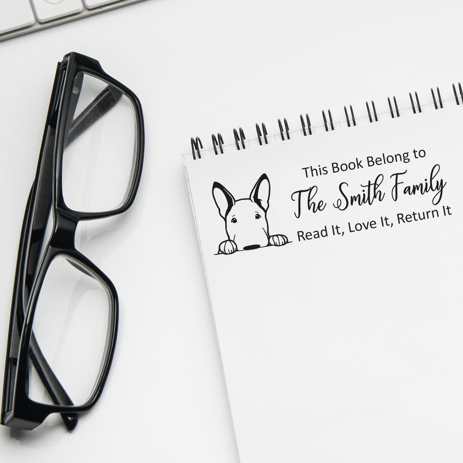Custom rubber book stamp for family library books, featuring dog design and This Book Belongs to The Smith Family imprint.