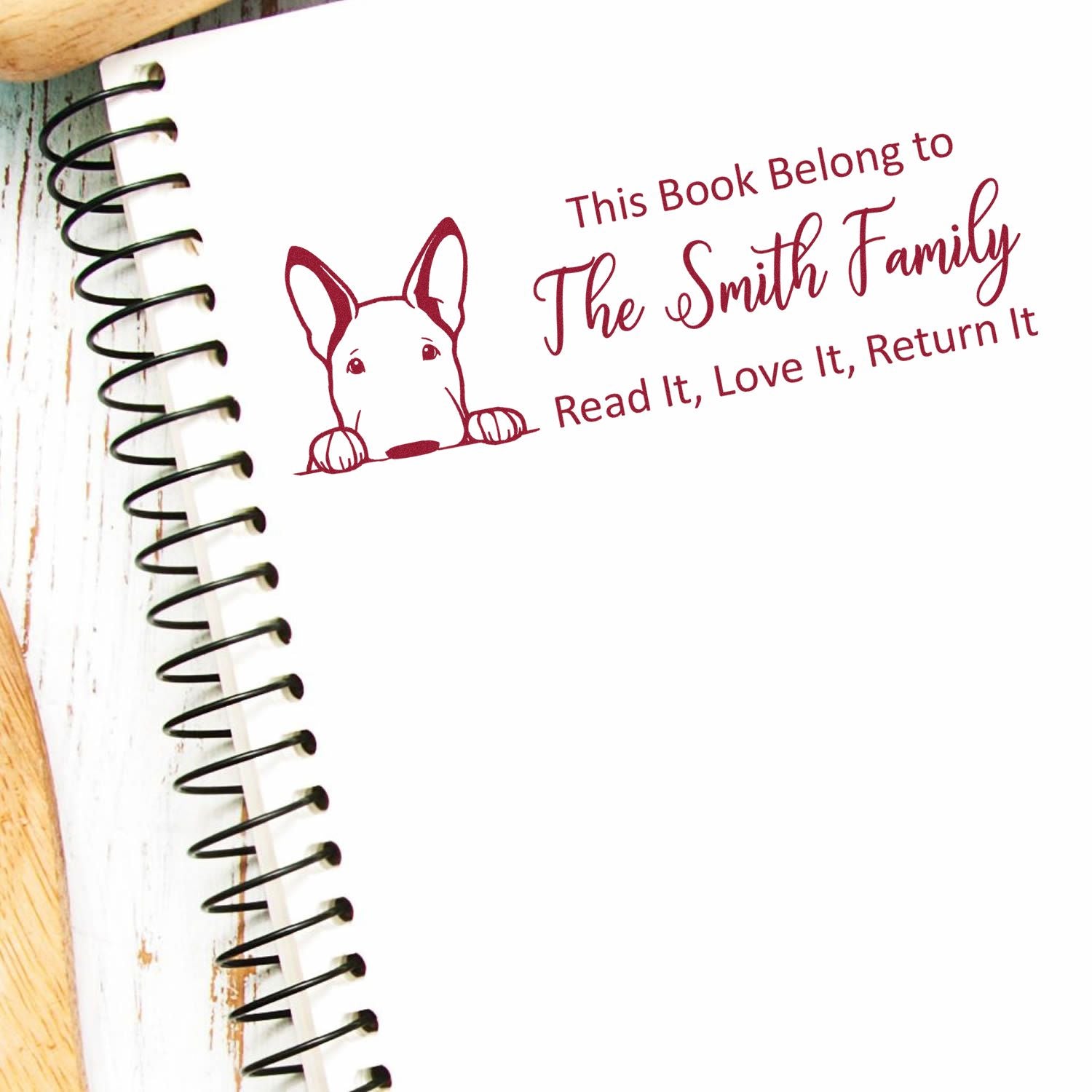 Custom rubber stamp for books with dog illustration and This Book Belongs to The Smith Family return-to-owner message.