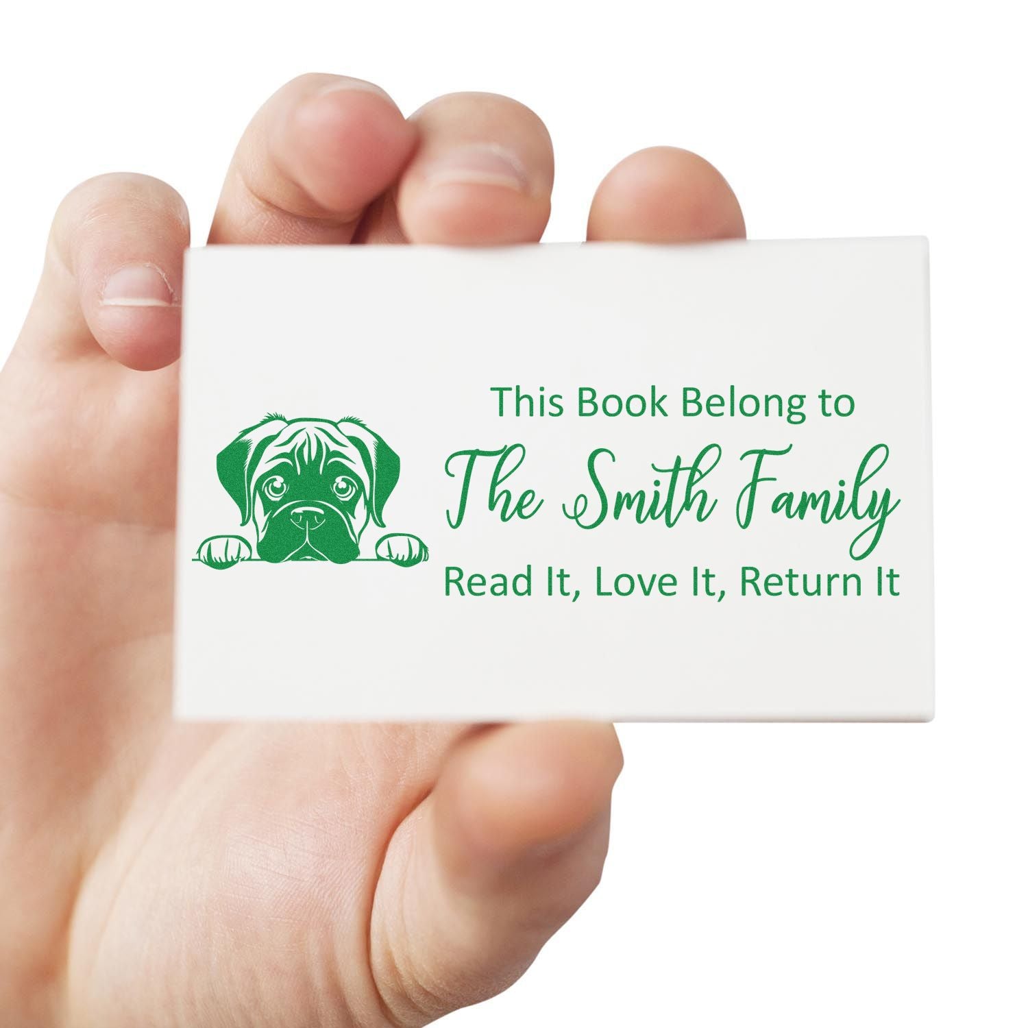 Hand holding custom book stamp with dog design and This Book Belong to The Smith Family return-book label.