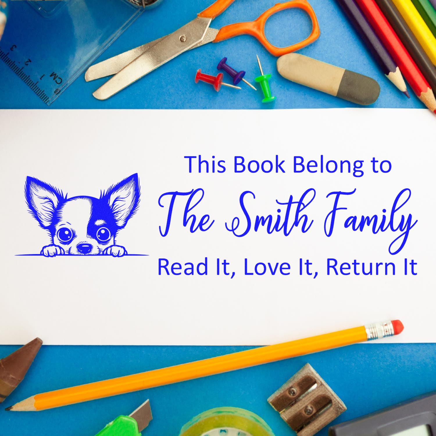 Personalized rubber book stamp with dog illustration for library labeling: This Book Belongs to The Smith Family.