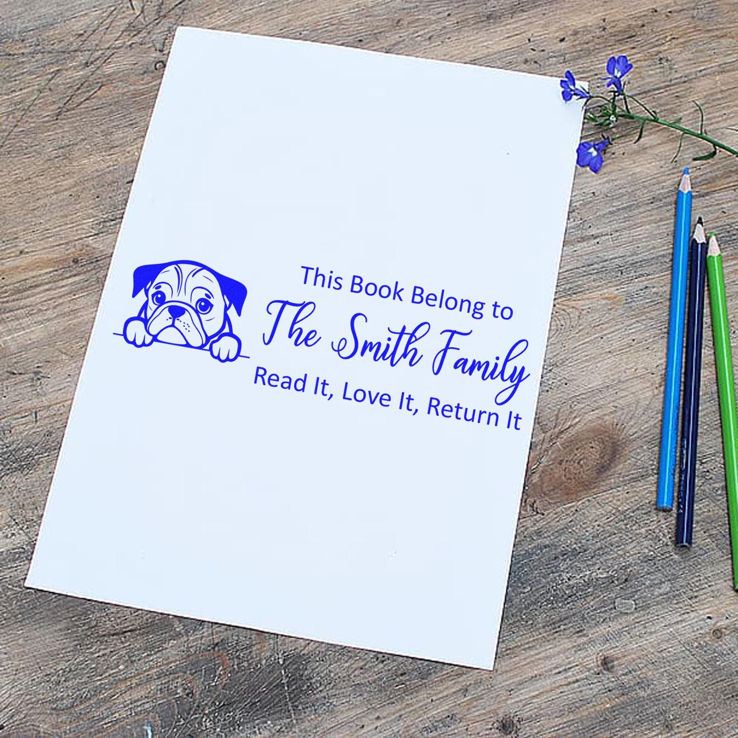 Personalized rubber book stamp with dog design, marking books for The Smith Family: Read It, Love It, Return It.