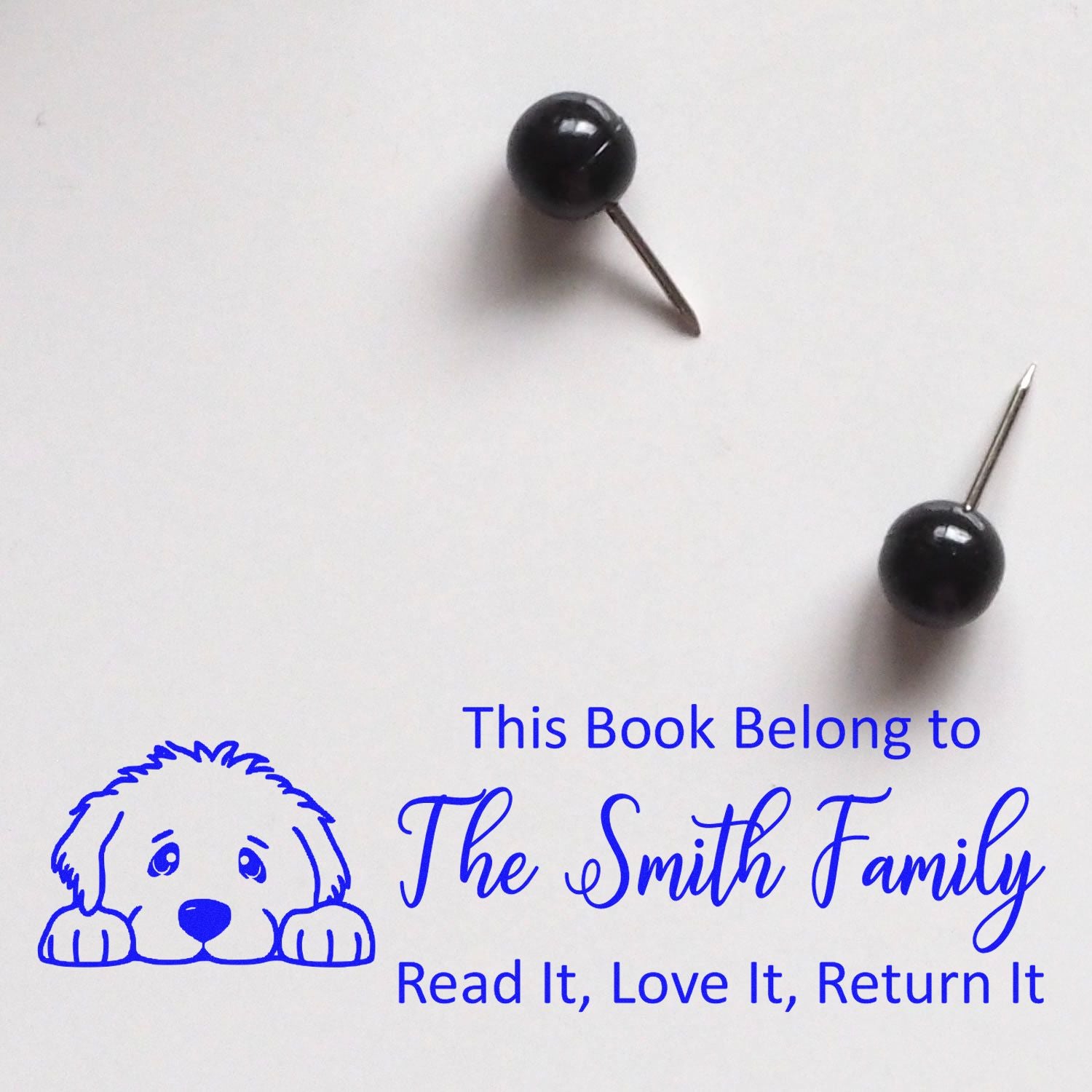 Personalized book rubber stamp with dog design and This Book Belong to The Smith Family return message.
