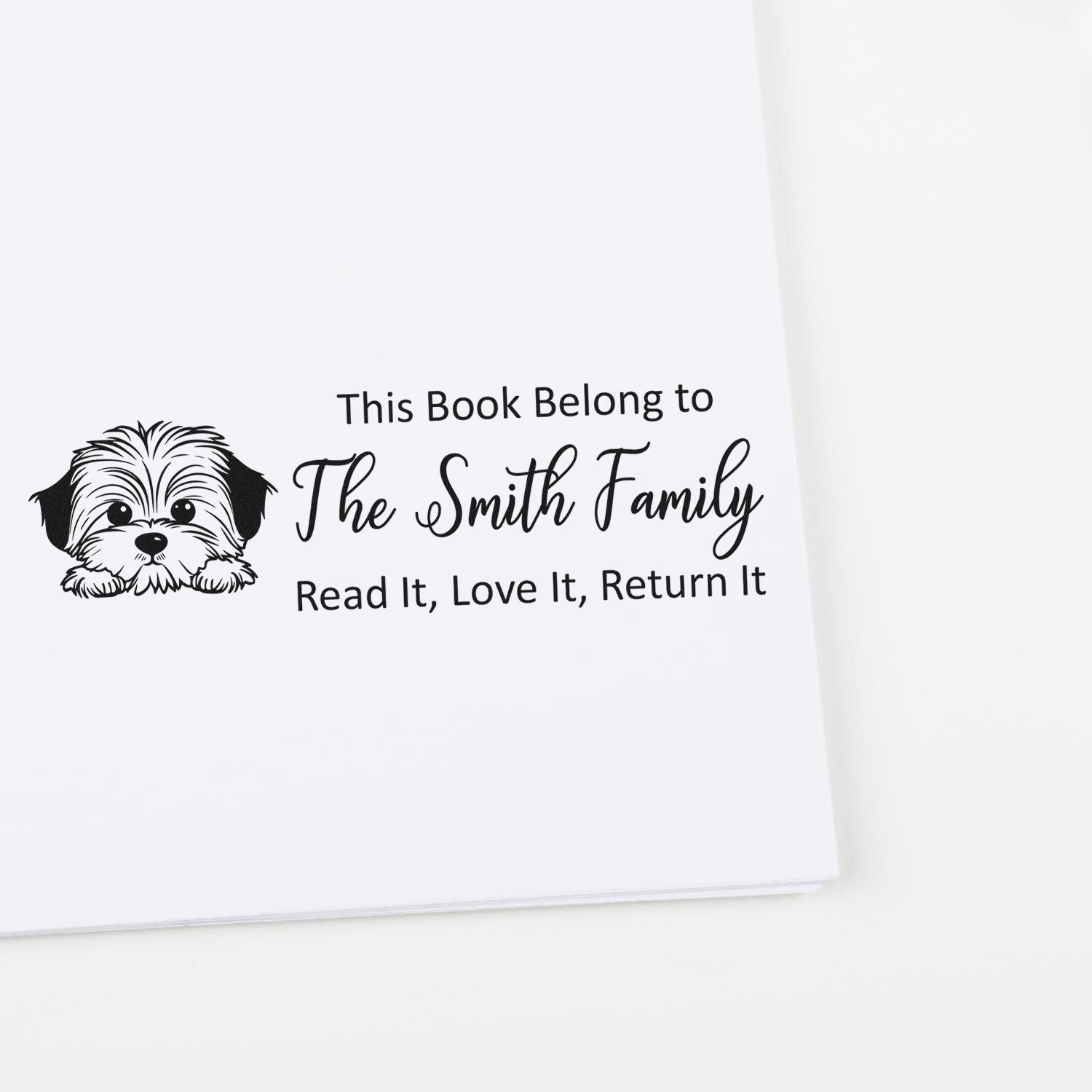 Personalized rubber stamp for books with dog illustration and This Book Belong to The Smith Family return-it message.