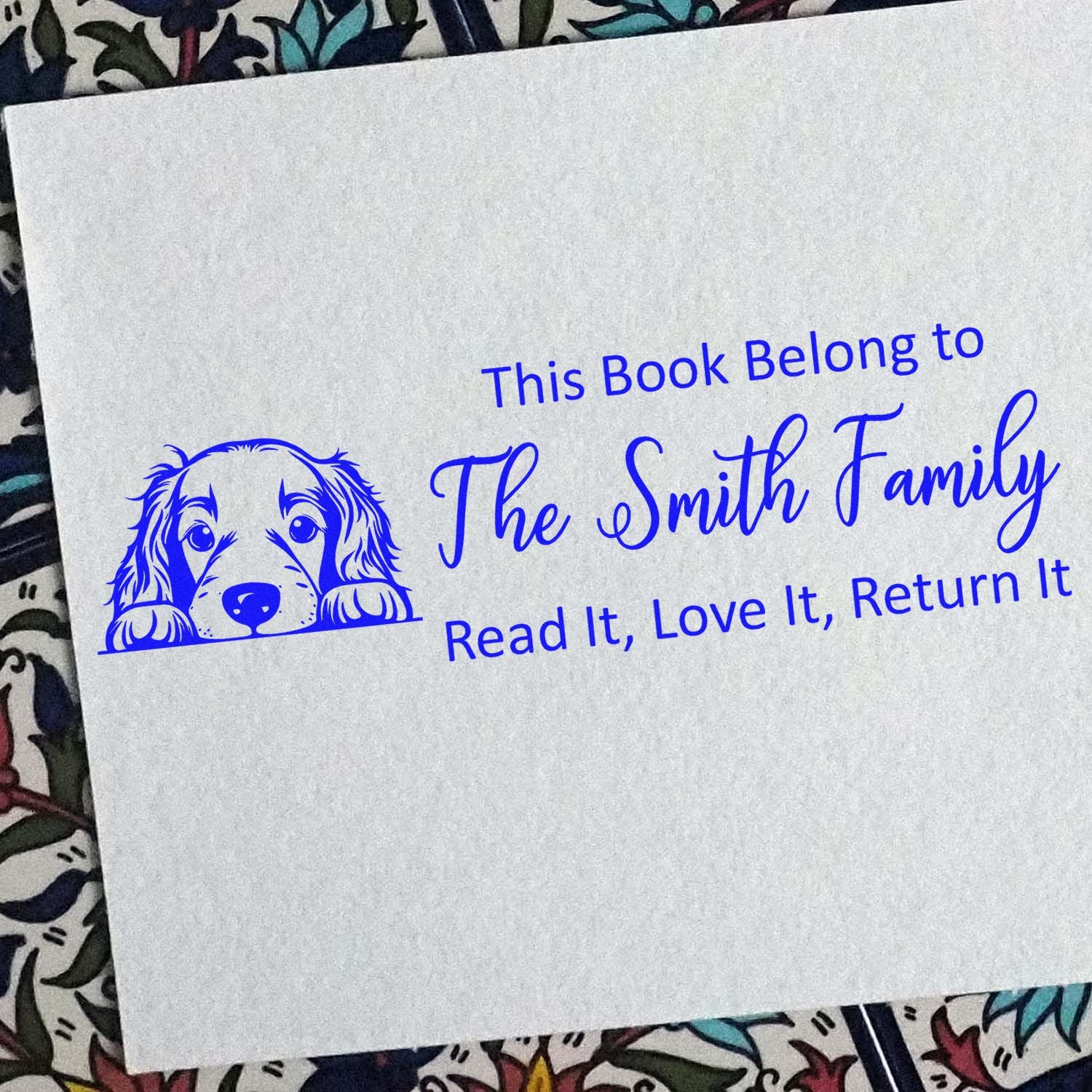 Personalized book rubber stamp with dog illustration and This Book Belongs to The Smith Family return message.