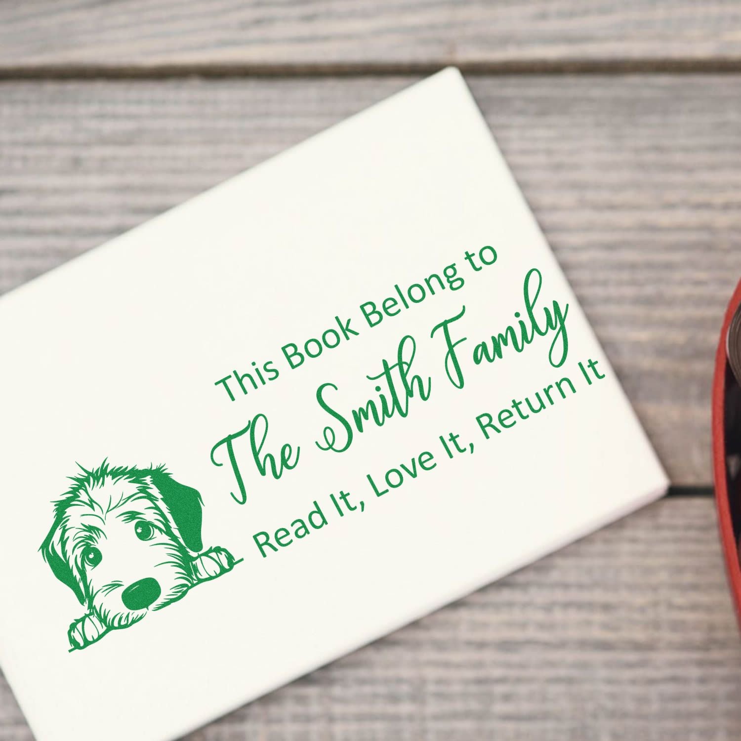 Personalized rubber book stamp with dog graphic for The Smith Family, reading: This Book Belongs to... Read It, Love It, Return It.