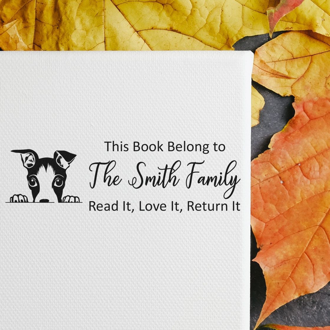 Custom rubber stamp for family books, with dog design and This Book Belongs to The Smith Family return message.