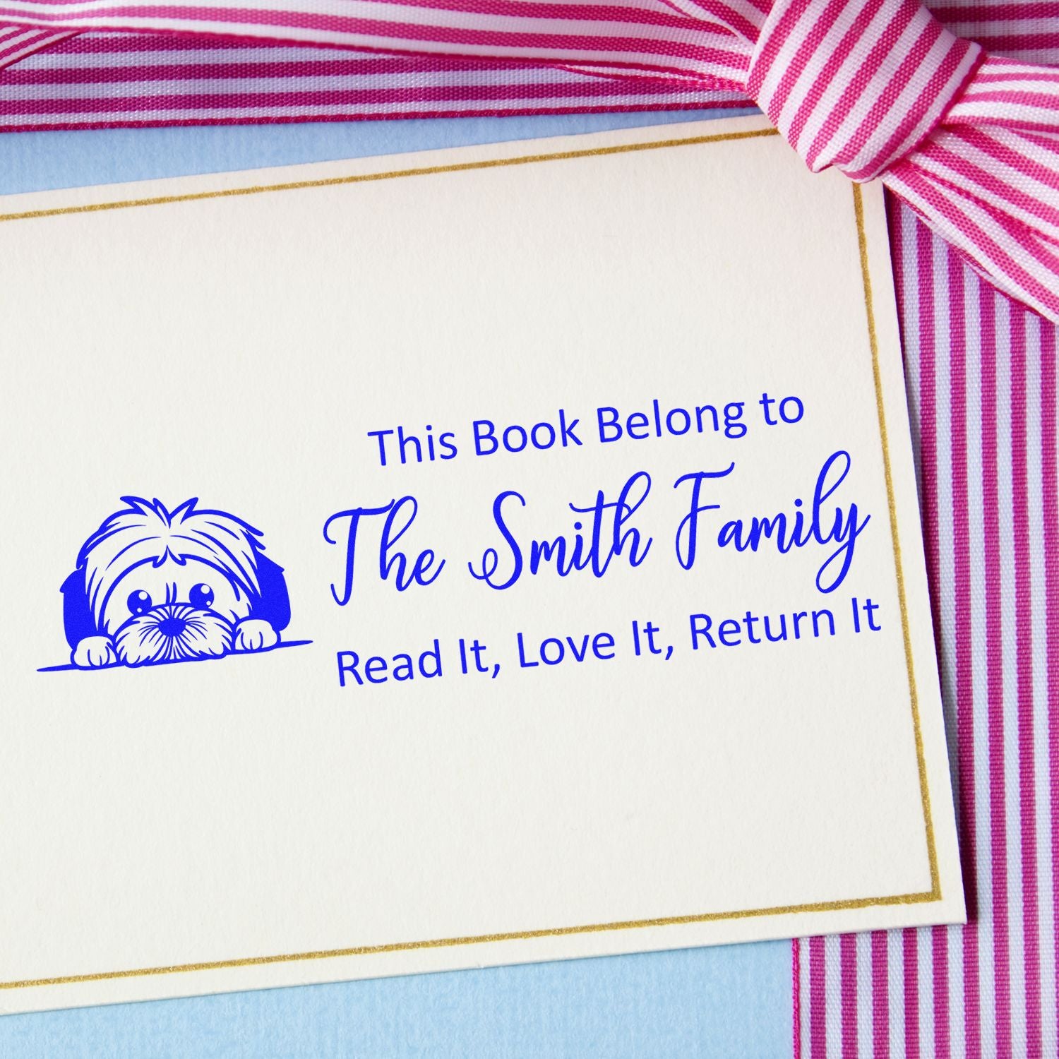 Personalized rubber book stamp with dog illustration and This Book Belong to The Smith Family return-it message.
