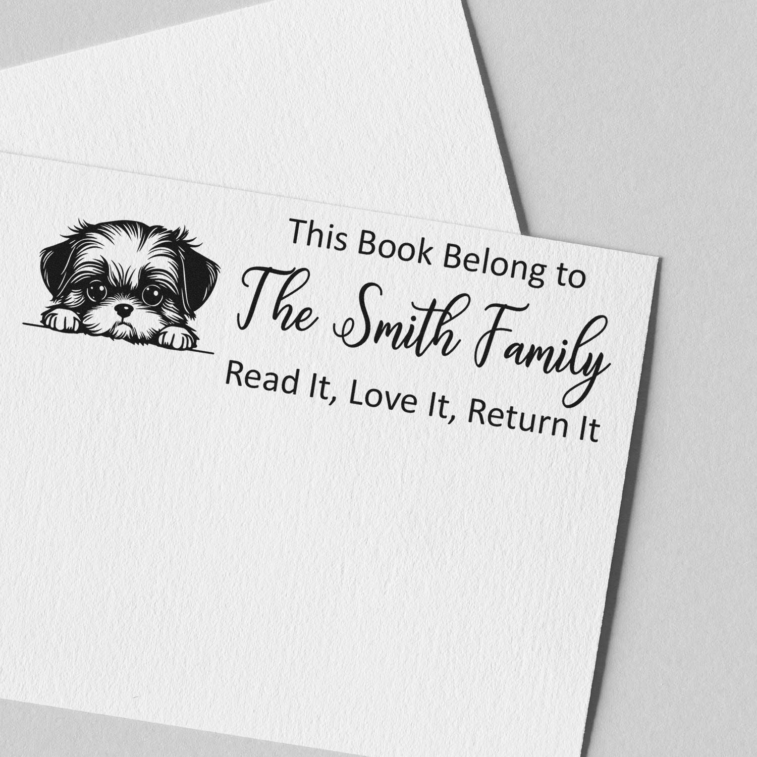 Custom rubber stamp for books with puppy design and This Book Belongs to The Smith Family return-it message.