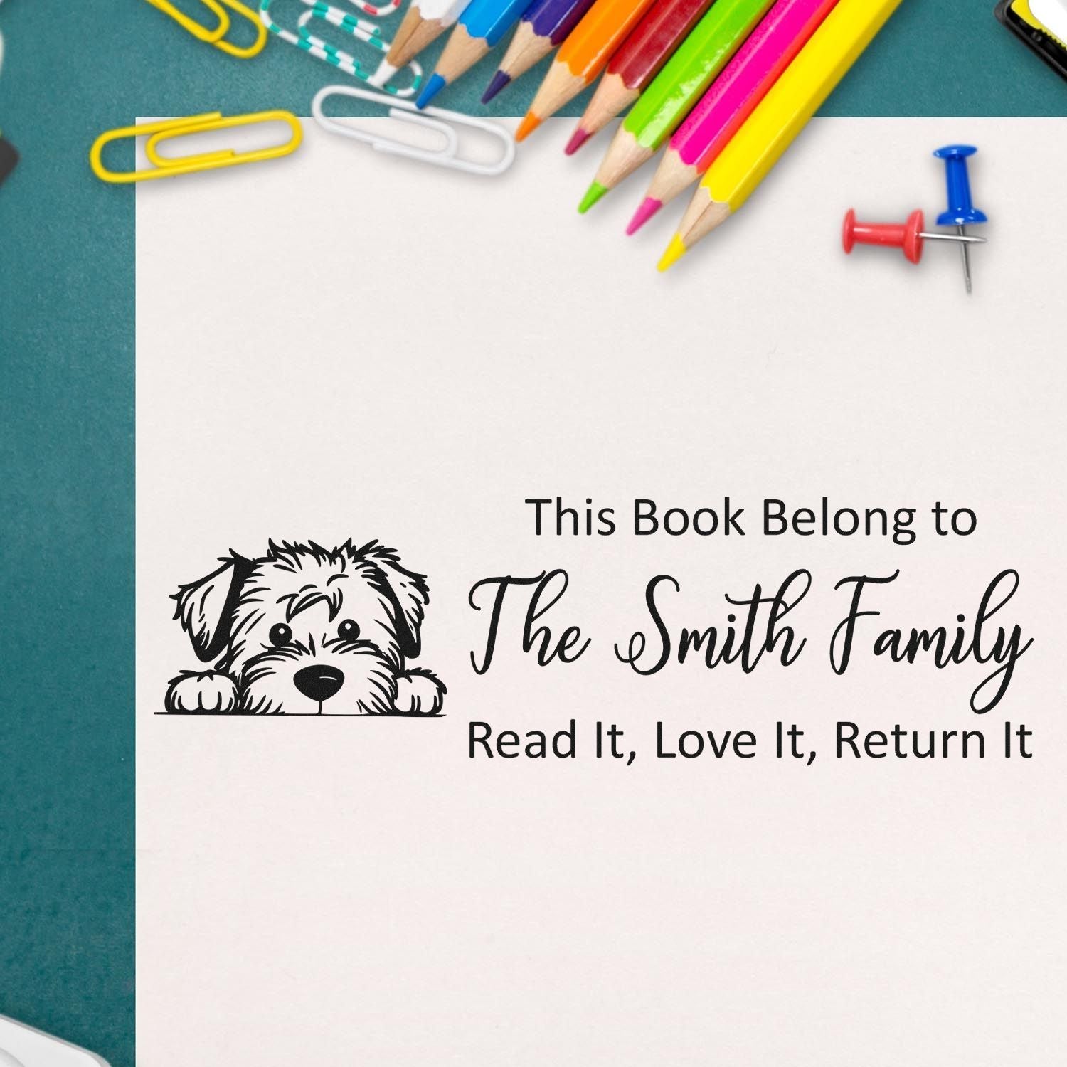 Personalized rubber book stamp with dog graphic and "This Book Belongs to The Smith Family" read-it, love-it, return-it message.