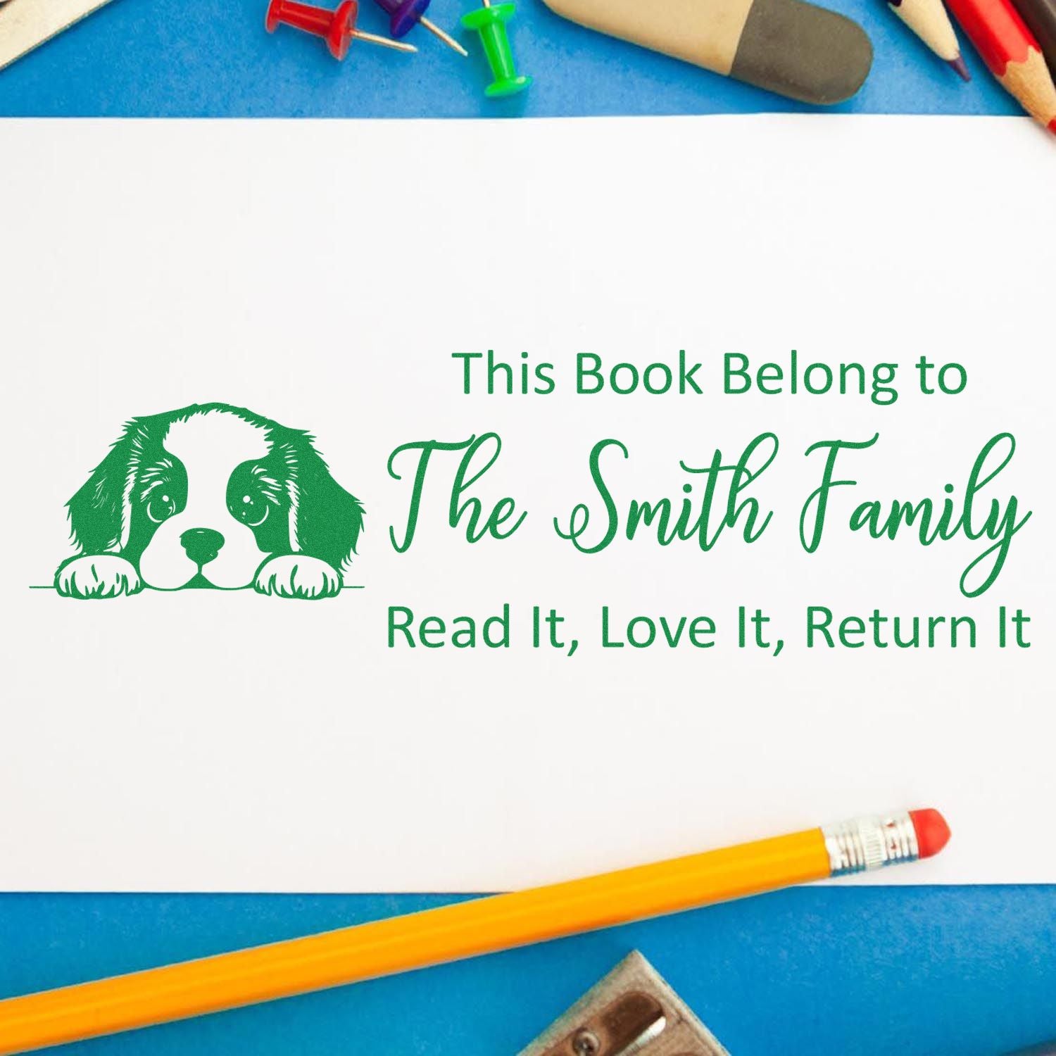 Personalized rubber stamp bookplate with dog design and This Book Belongs to The Smith Family return-book message.