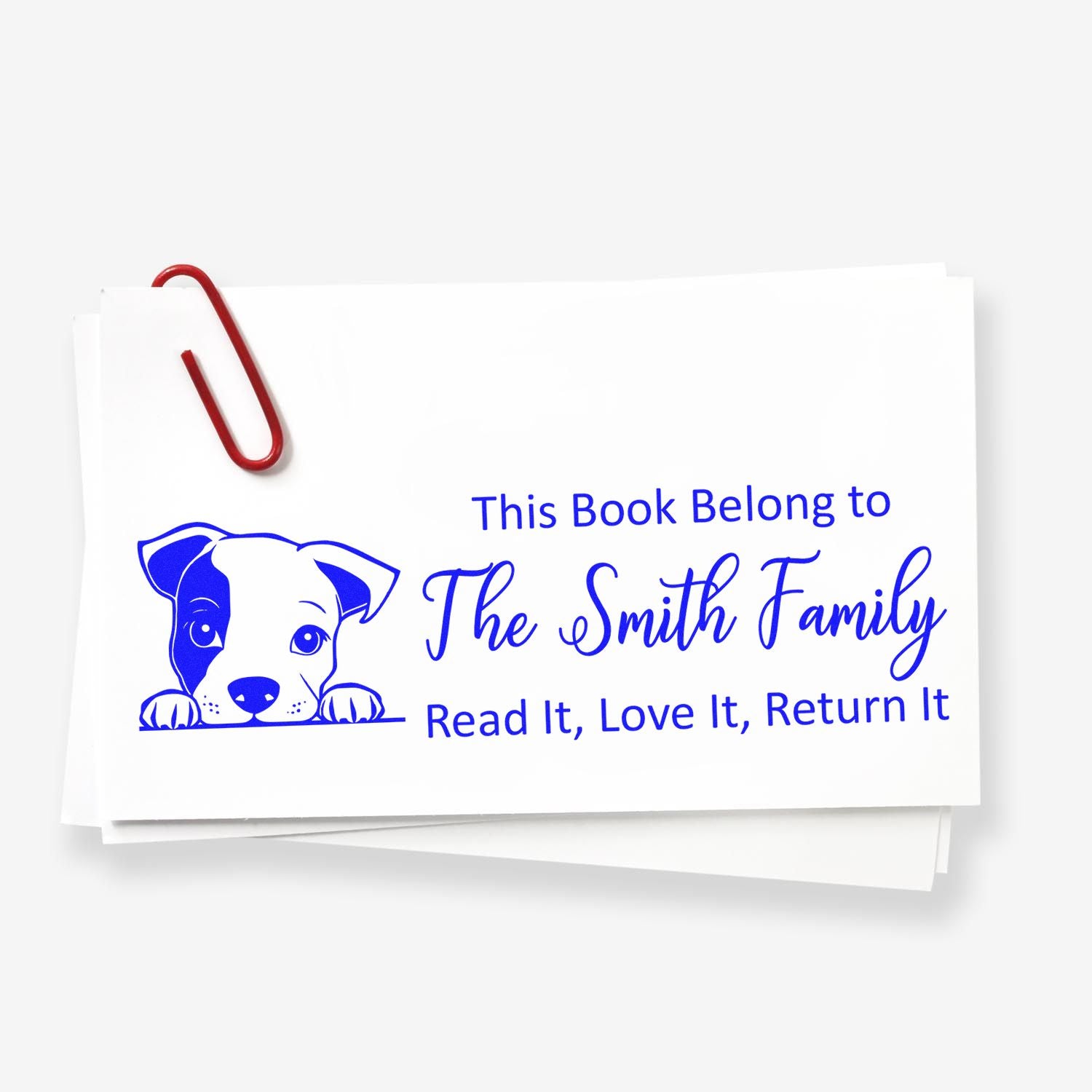 Personalized rubber book stamp with dog illustration and This Book Belongs to The Smith Family return message.