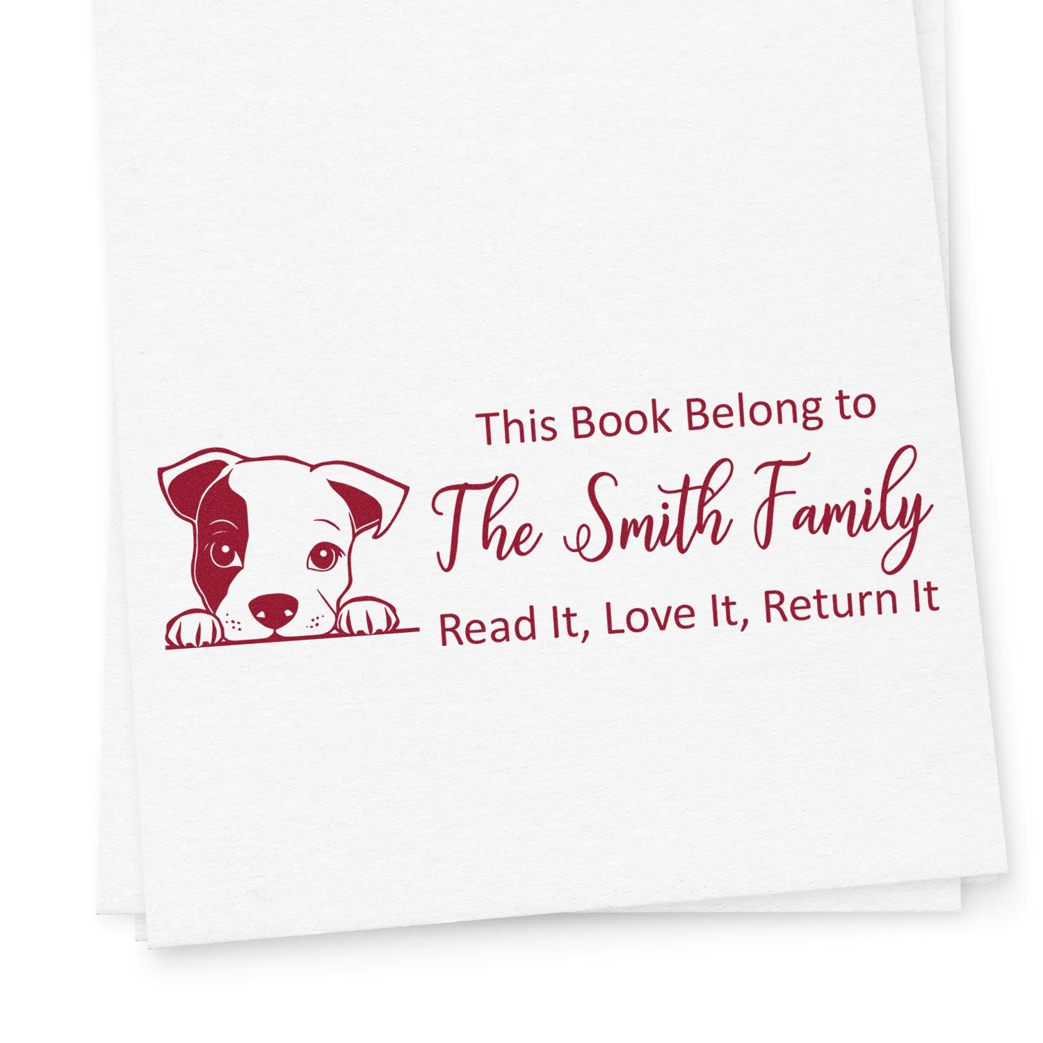 Personalized rubber book stamp with dog design for The Smith Family, marking books with Read It, Love It, Return It.