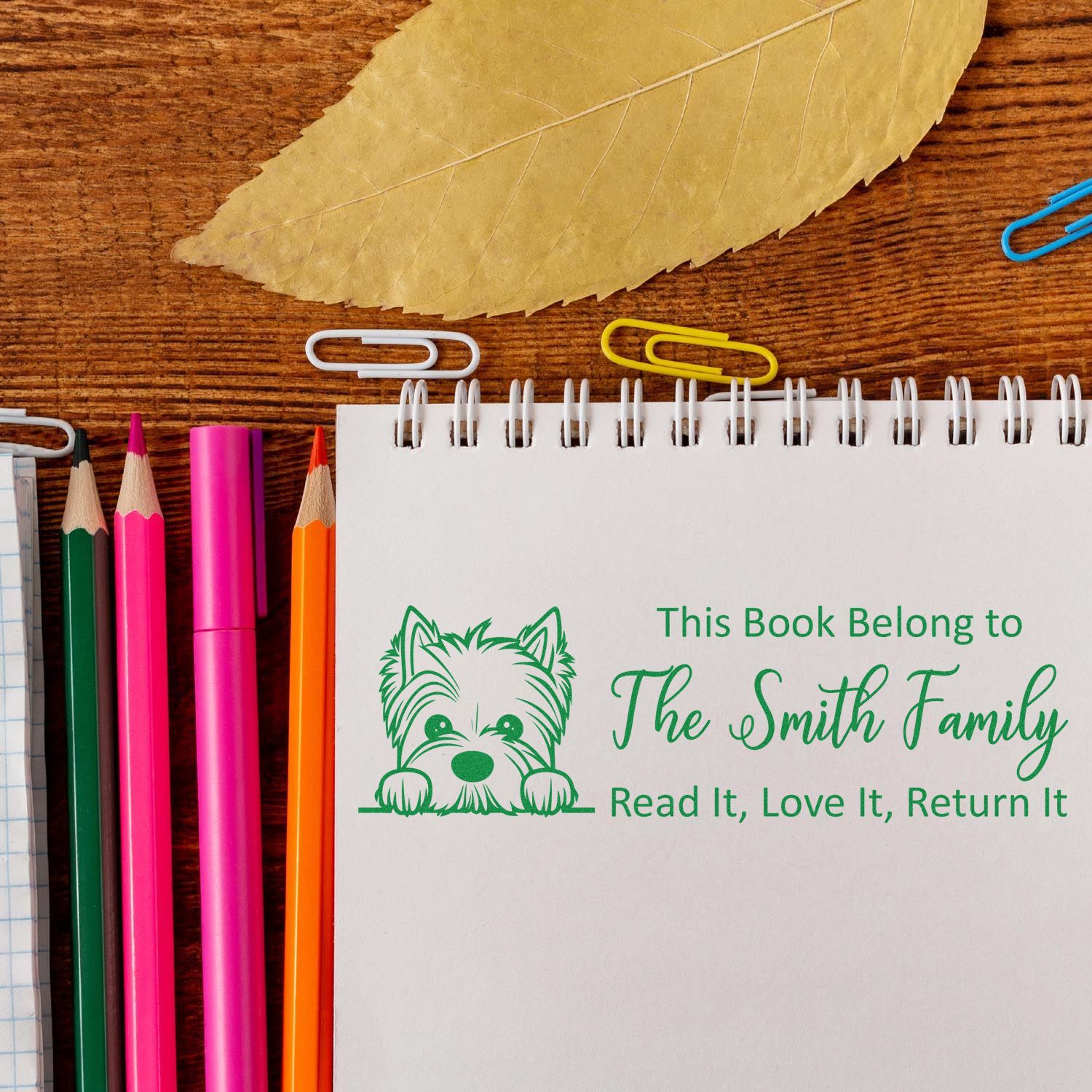 Personalized rubber book stamp with dog design and This Book Belongs to The Smith Family text for home libraries.