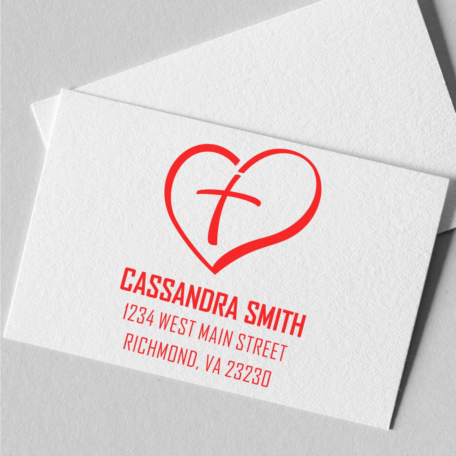 Custom return address rubber stamp with heart cross logo on envelope, ideal for Christian wedding invitations and mailings.