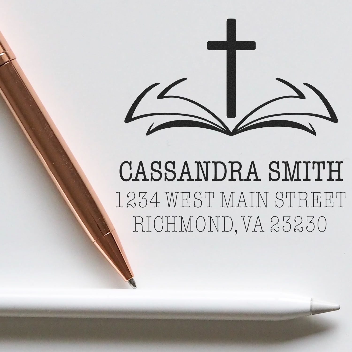 Custom Christian return address rubber stamp with cross over open book, featuring name and Richmond, VA address.