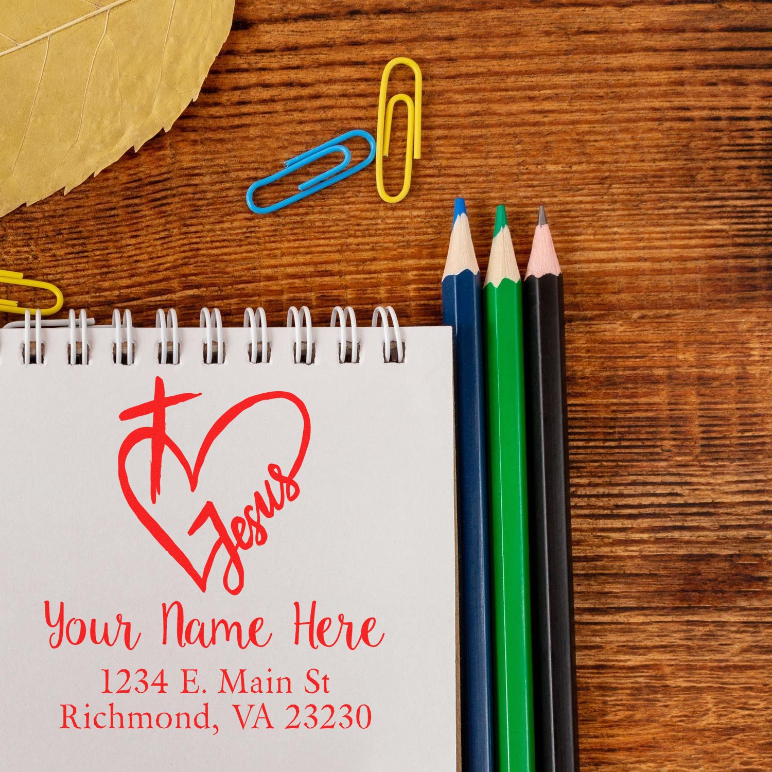 Personalized Christian rubber stamp sample with heart and Jesus, name, and address on a notebook.