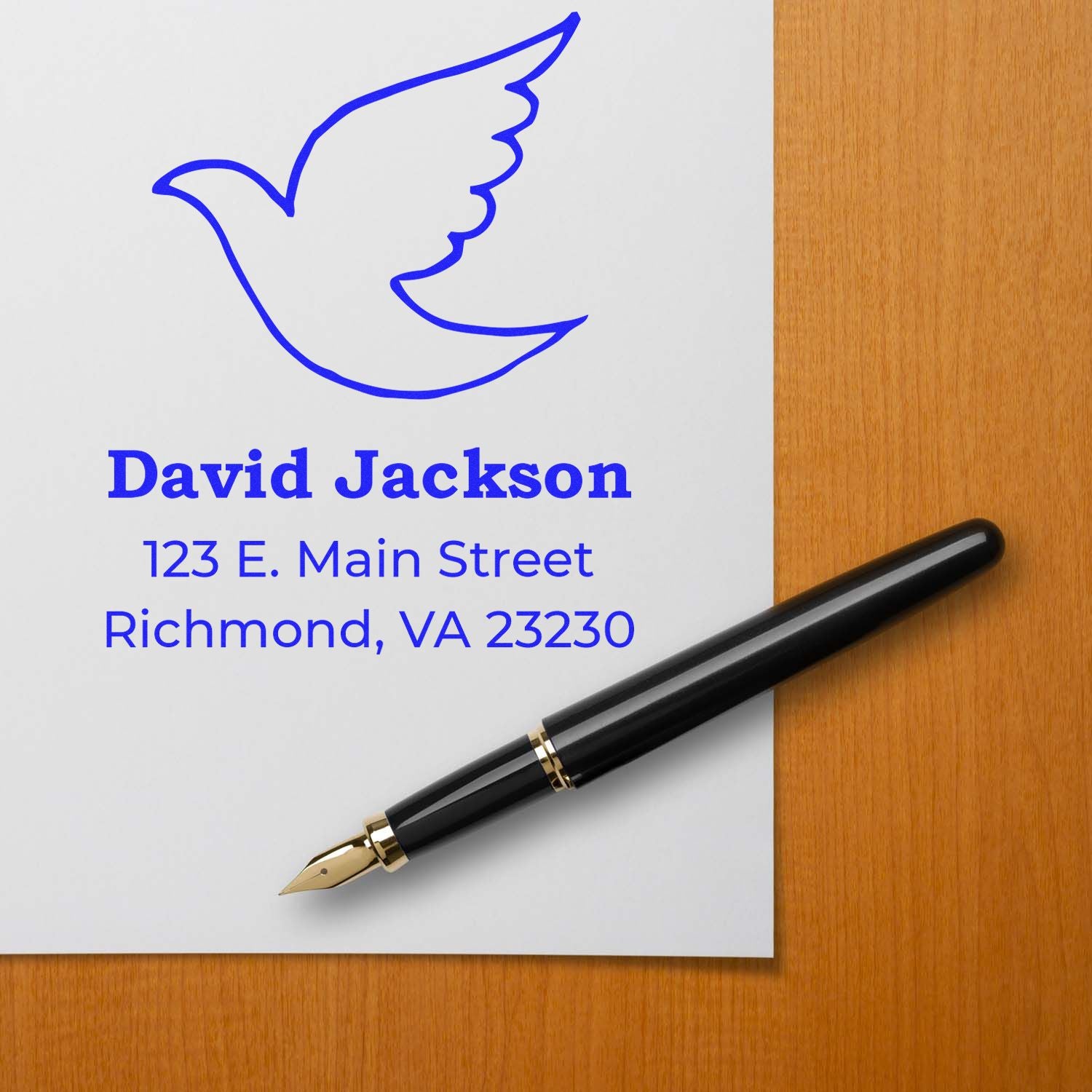 Custom return address rubber stamp with dove logo for David Jackson, Richmond, VA address, shown beside a pen on a desk.