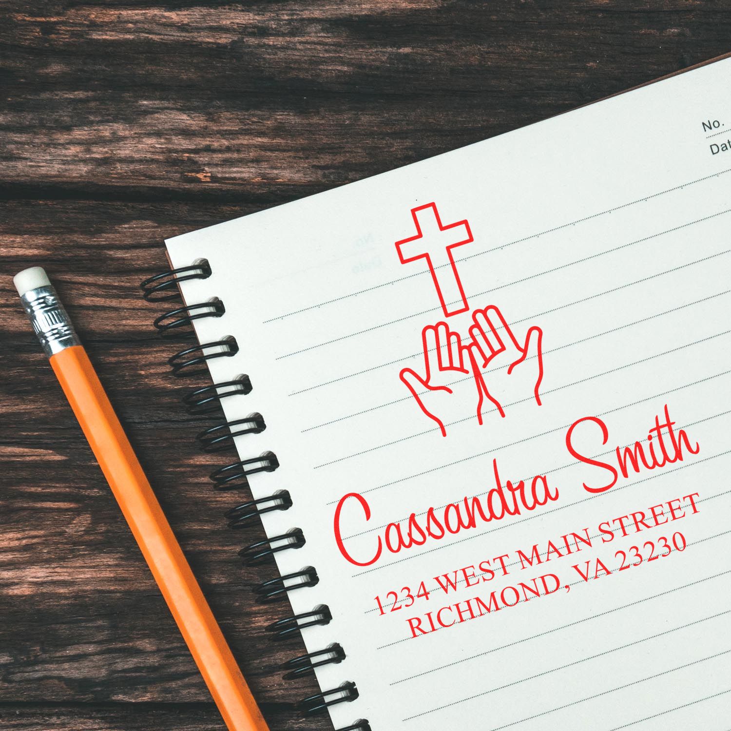 Custom church rubber stamp on notebook with cross, praying hands, and return address for Christian stationery.
