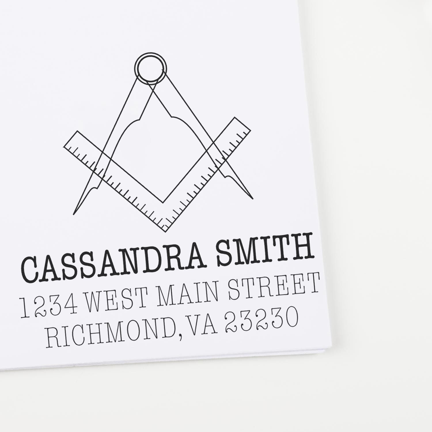 Custom rubber address stamp with compass-and-ruler design, featuring Cassandra Smith and Richmond, VA address.
