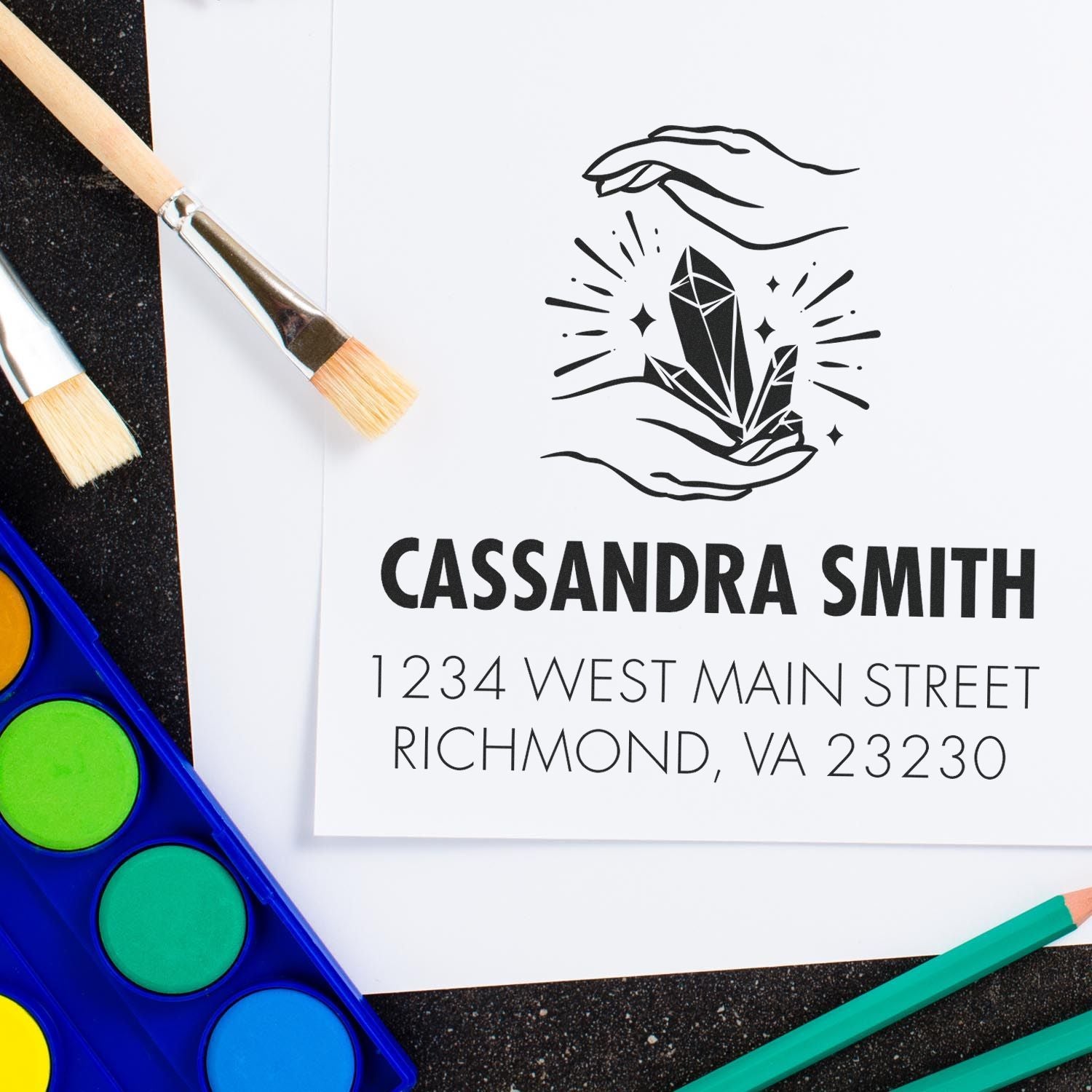 Personalized rubber stamp design with crystal logo, name, and return address for artist branding.
