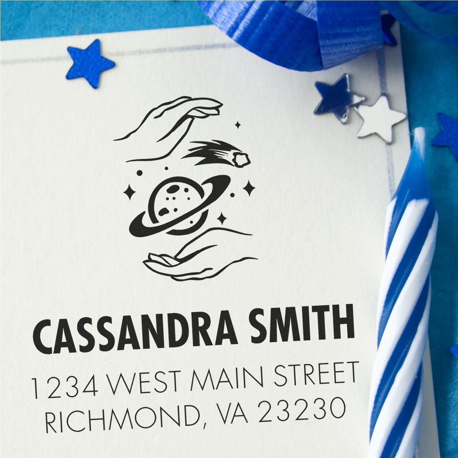 Personalized rubber address stamp with space-themed hands, planet and stars for Cassandra Smith, Richmond, VA.