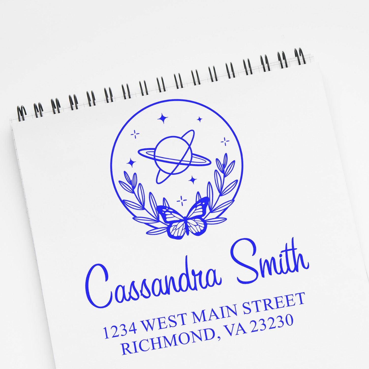 Personalized rubber stamp with name and return address, featuring a butterfly and planet design for stationery.