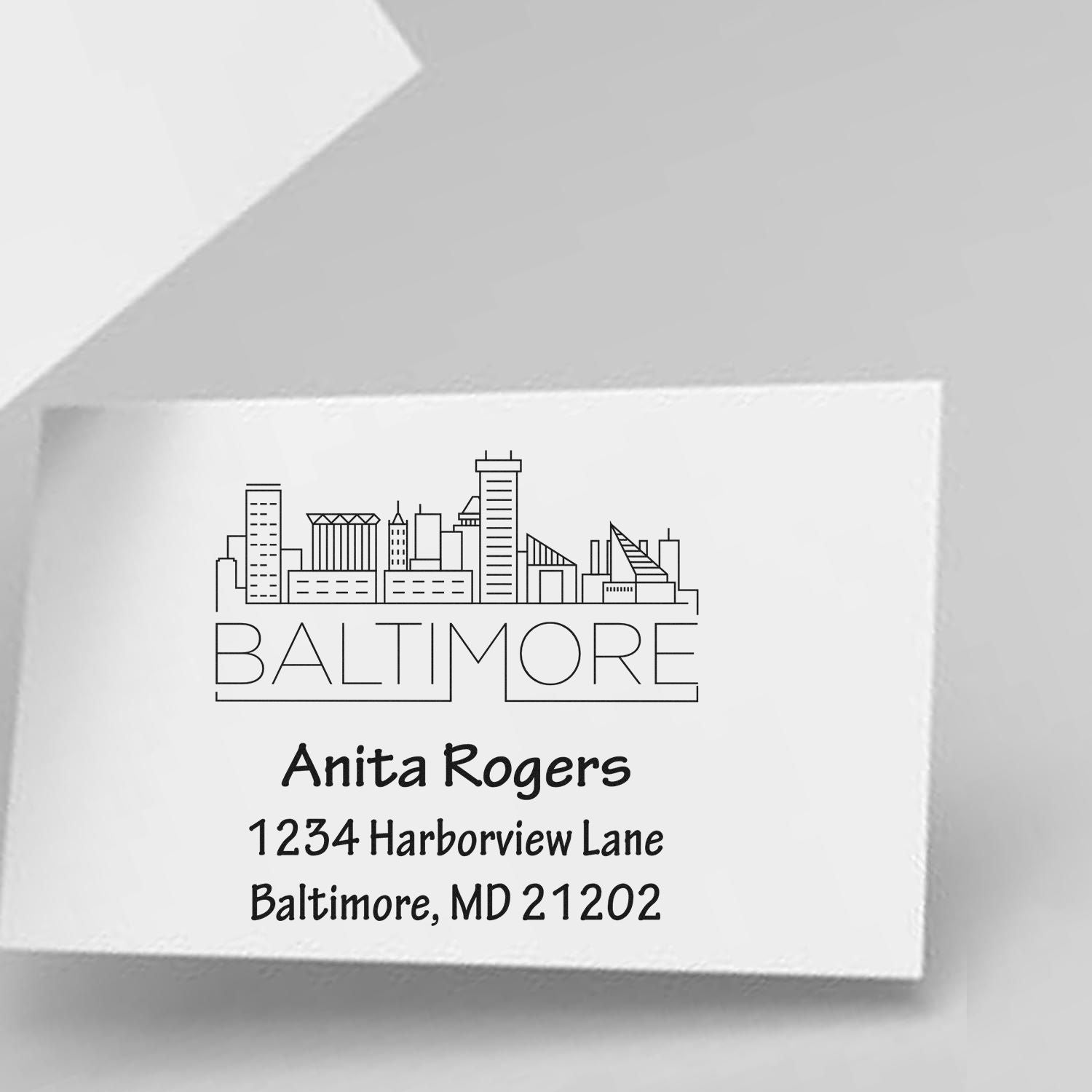 Custom Baltimore skyline address rubber stamp with name Anita Rogers and address 1234 Harborview Lane, MD 21202.
