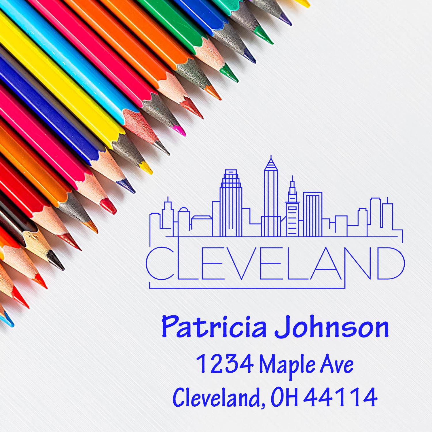 Personalized Cleveland return address rubber stamp with skyline, name and address, shown with colored pencils.