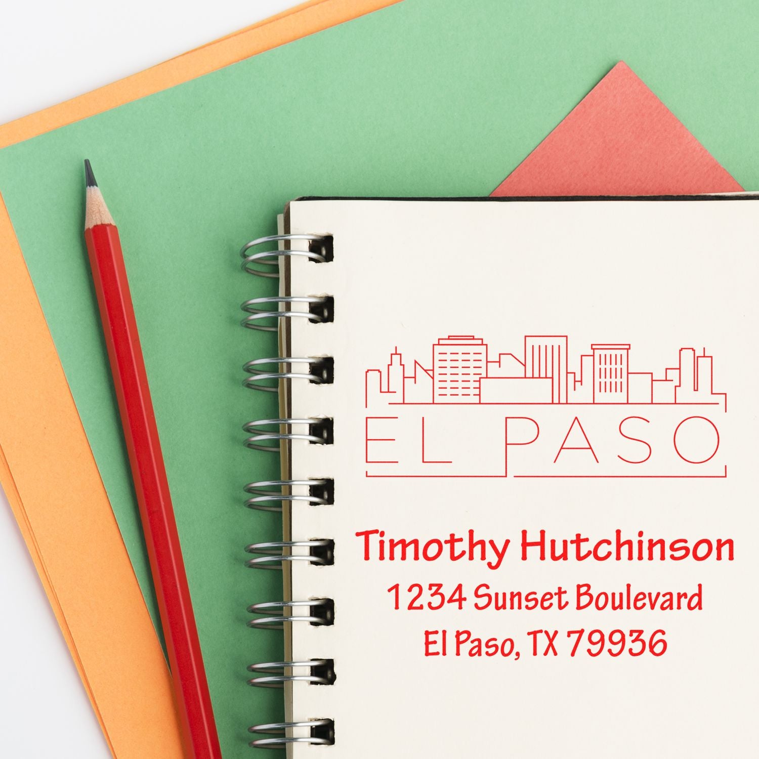 Custom El Paso address rubber stamp with skyline design, showing a name and address imprint on a notebook page.