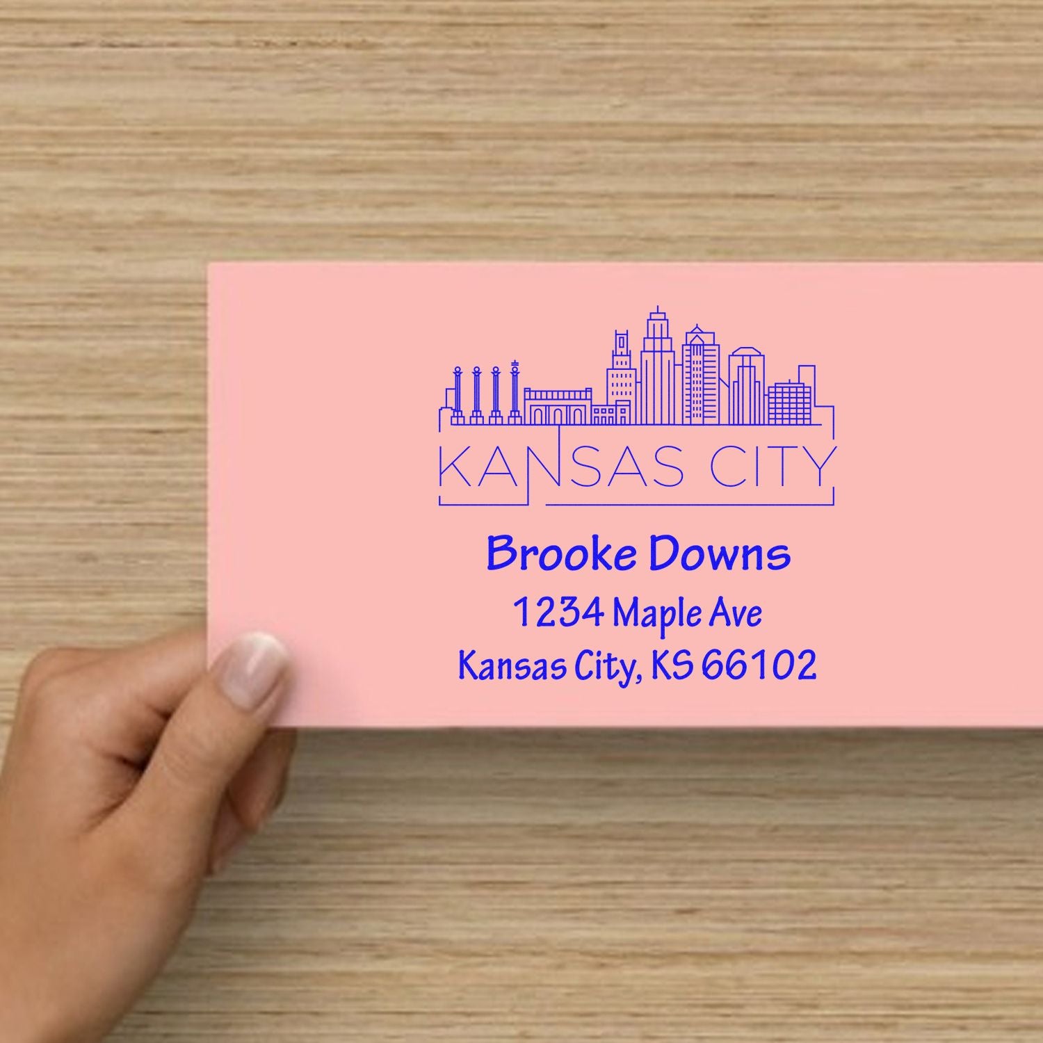 Custom Kansas City return address rubber stamp with skyline design on a pink envelope for personalized mailings.