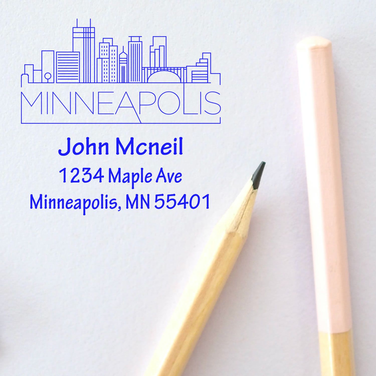 Personalized return address rubber stamp with Minneapolis skyline, name, and address for custom mail labeling.