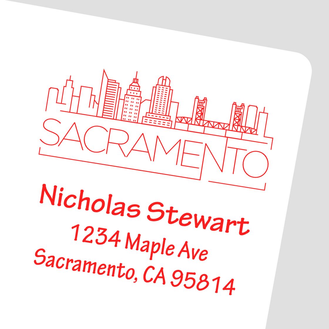 Custom Sacramento rubber address stamp with skyline, Nicholas Stewart name, and return address for business mailings.