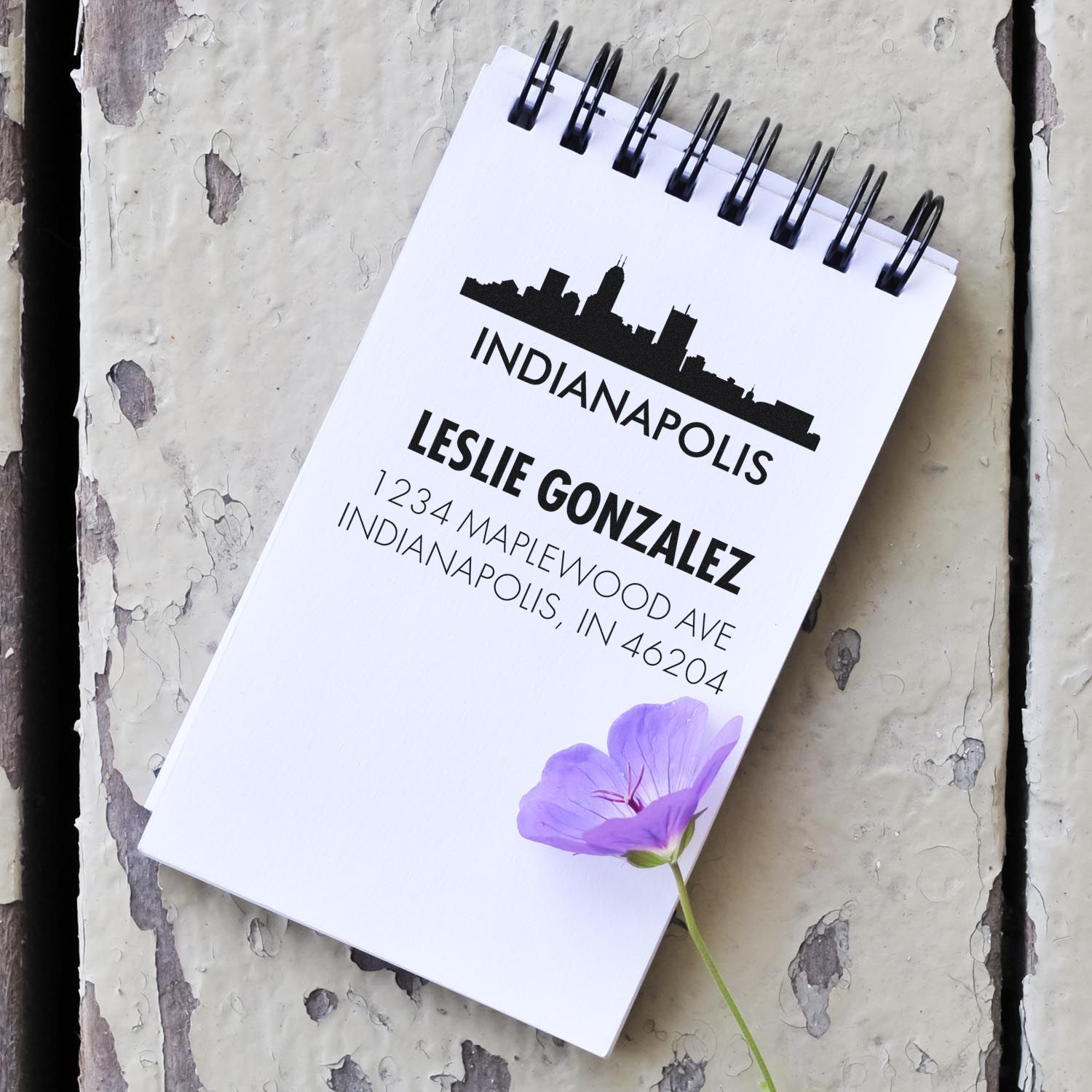 Custom rubber stamp design with Indianapolis skyline, Leslie Gonzalez name, and return address on a spiral notepad.