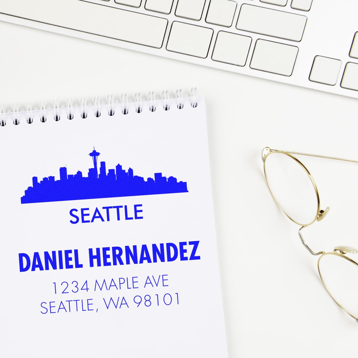 Personalized Seattle return address rubber stamp with skyline, name, and address on notebook.