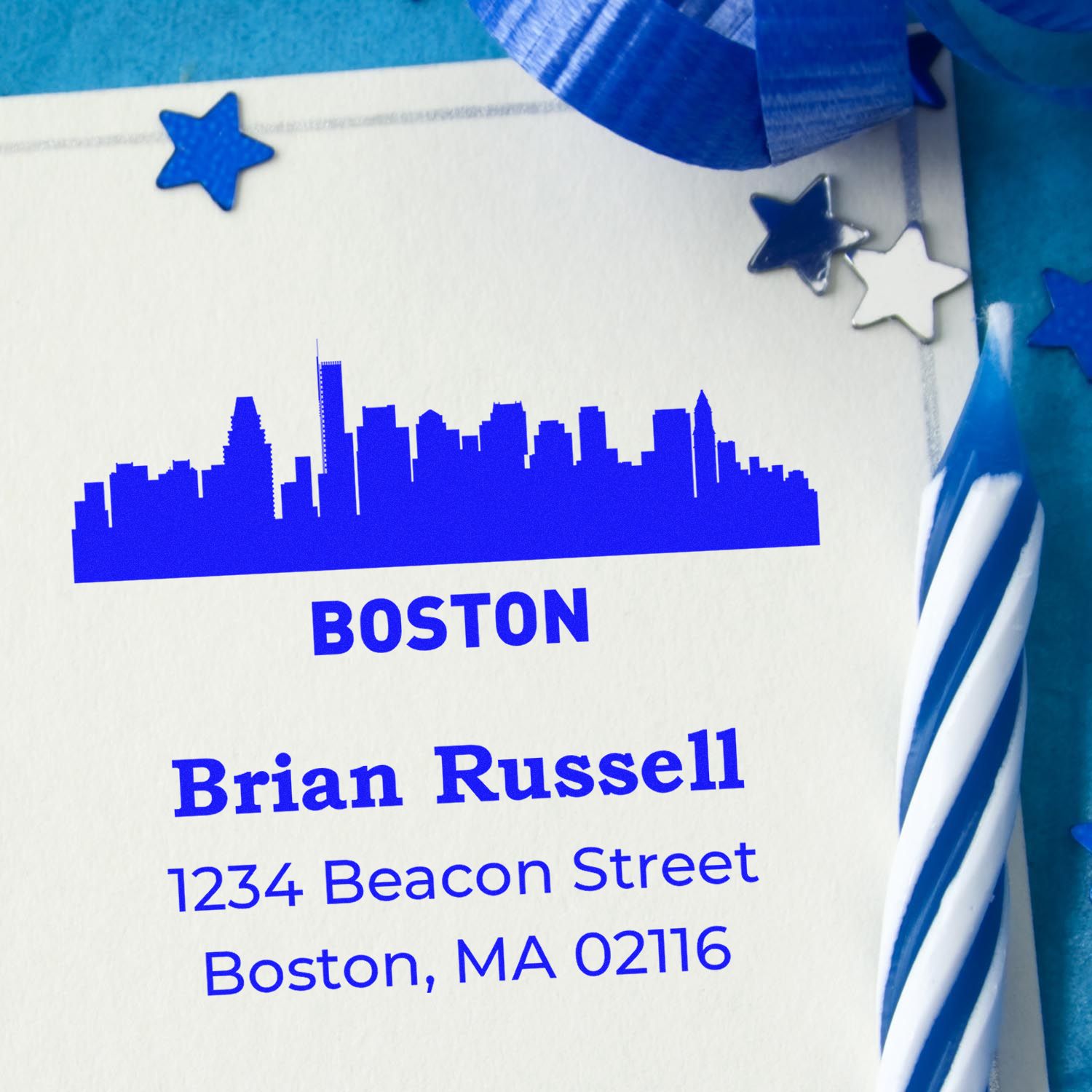 Custom Boston address rubber stamp with skyline, name, and mailing address in blue ink on stationery.
