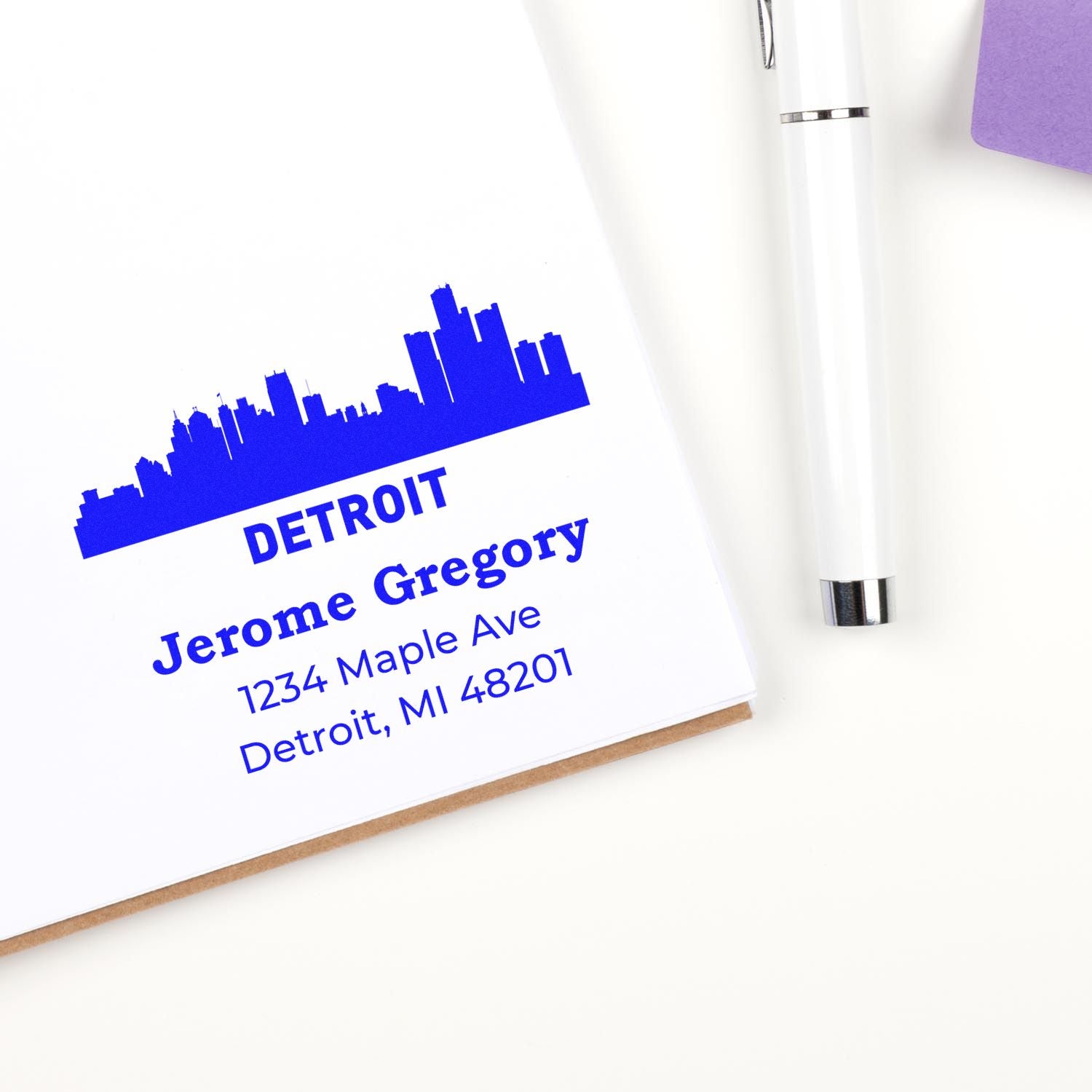 Custom rubber address stamp featuring Detroit skyline, name, and address for personalized mailing and business branding.